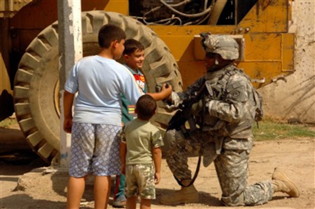 A U.S. Army soldier from the 1st Armored Division interacts with Iraqi children during a patrol in the Otifiya neighborhood of Baghdad, Iraq, on Sept. 17, 2007.  