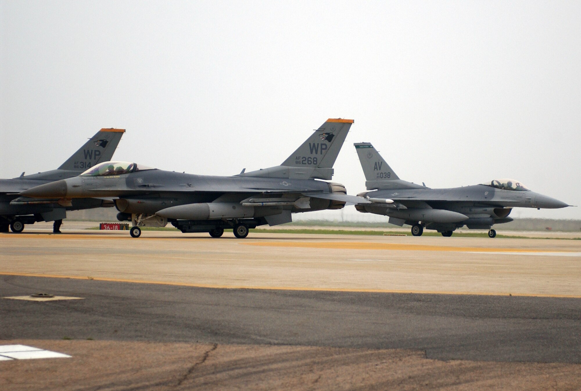 KUNSAN AIR BASE, Republic of Korea -- The 555th Expeditionary Fighter Squadron has began to redeploy back to their home Aviano Air Base, Italy after a four month deployment here. During the deployment the unit trained along side 8th Fihgter Wing pilots as shown here as an F-16 from the 555th Fighter Squadron, "Triple Nickel", taxi's by 80th Fighter Squadron F-16's after returning from a training mission during the Peninsula Operational Readiness Exercise July 26. (U.S. Air Force photo/Senior Airman Steven R. Doty)                                