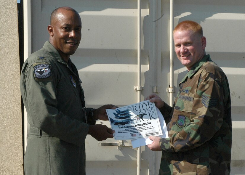 KUNSAN AIR BASE, South Korea -- Colonel CQ "Wolf" Brown, 8th Fighter Wing commander, congratulates Staff Sgt. Jeffrey McCoy from the 35th Aircraft Maintenance Unit, here Sept. 25. Sergeant McCoy was selected as the 8th Fighter Wing's Pride of the Pack for the week of Sept. 24. (U.S. Air Force photo/Staff Sgt. Araceli Alarcon)       