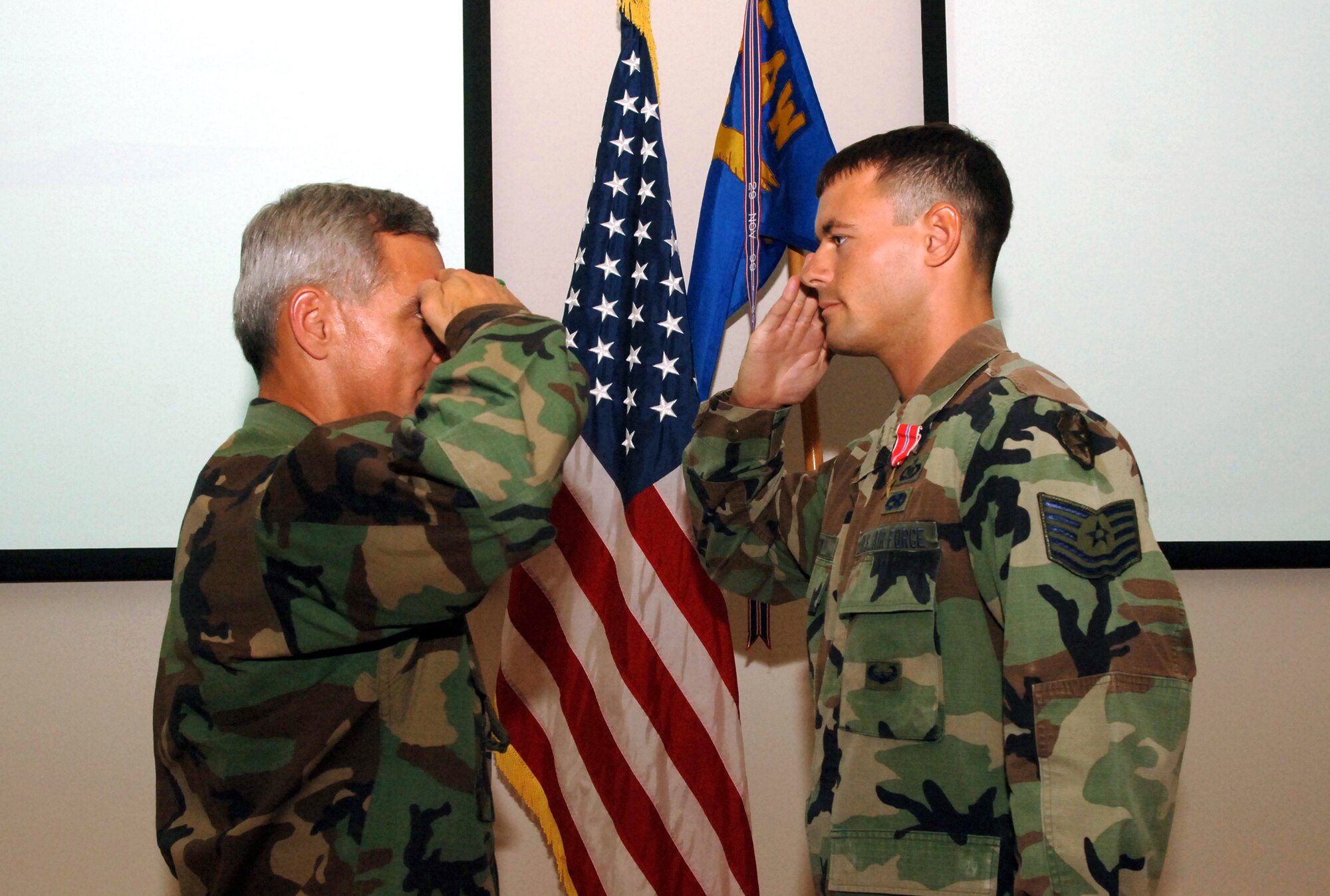 Tech. Sgt. Steven Reedy, 25th Air Support Operations Squadron, salutes Col. JJ Torres, 15th Airlift Wing commander, during a ceremomy at Hickam AFB, Oct. 4. Sergeant Reedy was presented the Bronze Star for his heroic actions.  Photo by Vanessa Perez.
