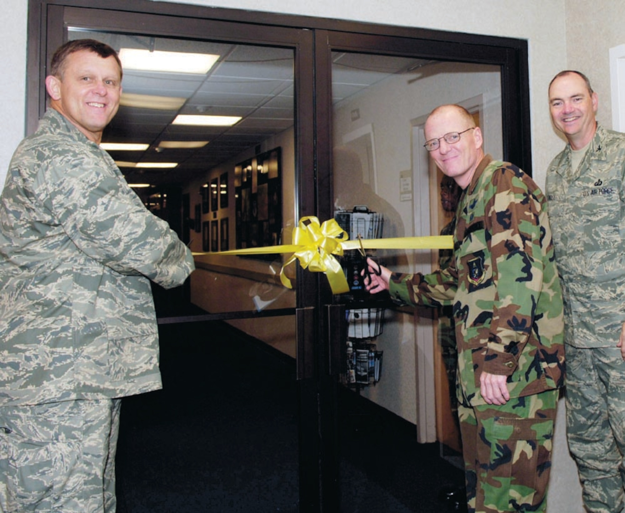 Maj. Gen. Frank Gorenc, Air Force District of Washington commander and Col. Terry Ross, 11th Wing vice commander, hold a yellow ribbon across the doors of the Chief Master Sergeant of the Air Force Donald L. Harlow Airman Leadership School as Col. Paul R. Ackerley, 316th Wing commander, cuts it on Sept. 28. The reopening of the leadership school signifies the combination of leadership schools for Bolling Air Force Base, Washington, D.C., and Andrews. (US Air Force/SrA Laura Cirksena)
