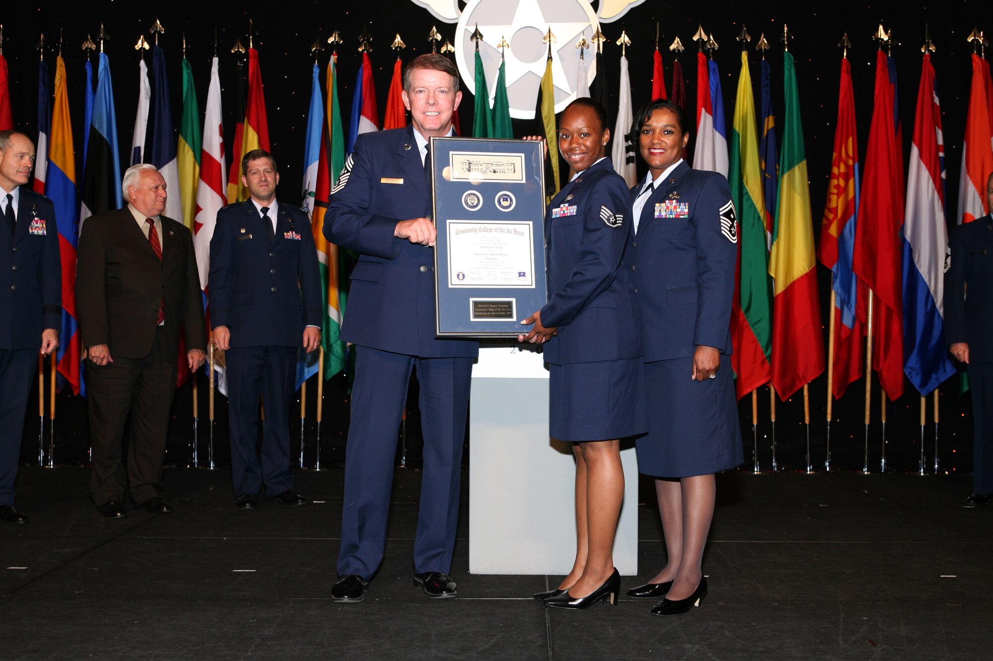 Chief Master Sgt. of the Air Force Rodney J. McKinley presents the 300,000th Community College of the Air Force degree to Staff Sgt. Danyail King during a ceremony at the Air Force Association's 2007 Air & Space Conference and Technology Exposition in Washington, D.C.  Standing with Sergeant King is her first sergeant, Senior Master Sgt. Cindy Riley.  (Photo courtesy of AFA/Christopher McCartin)