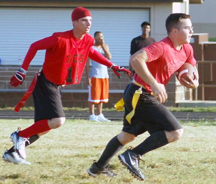 31st Combat Communications Squadron Red Bull punt returner Matthew Williams returns a punt while his teammate Justin Buckler escorts him up the field. (Air Force photo by John E. Banks)