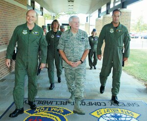 Gen. Arthur Lichte, commander, Air Mobility Command, Col. James Wolcott, 89th Operations Group commander, left, Brig. Gen. Margaret Woodward, 89th Airlift Wing commander, rear, and Lt. Col. Robert Holba, 89 OG deputy commander, right, enter the 99th Airlift Squadron's Squadron Operations Building during his tour of the 89 AW, Sept. 28. (US Air Force/A1C Renae Kleckner)