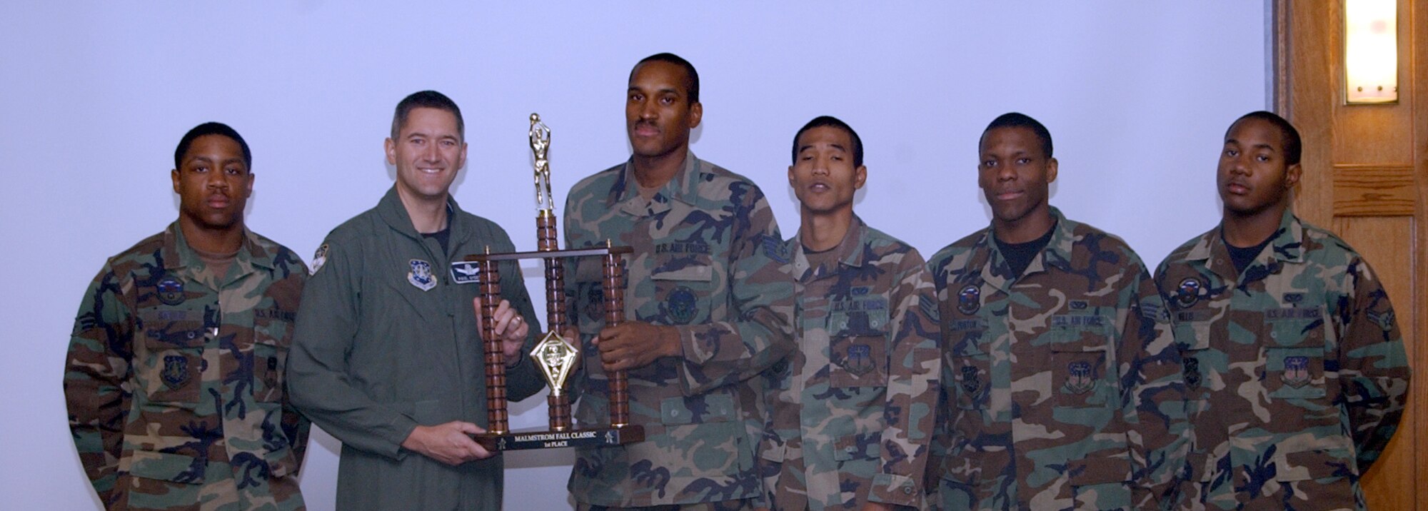 Members of Malmstrom's "A" men's basketball team, left to right, Airman 1st Class Rafael Spears, Staff Sgt. Aharon Goins, Staff Sgt. Leon Grier, Senior Airman Jamie Poston and Airman 1st Class Marquelle Willis, presented the championship trophy from the Fall Classic Basketball Tournament to Col. Paul Gydesen, 341st Space Wing vice commander, during Wing Stand Up Oct. 1. The team won the tournament which was held here Sept. 28 to 30. (U.S. Air Force photo/Valerie Mullett)