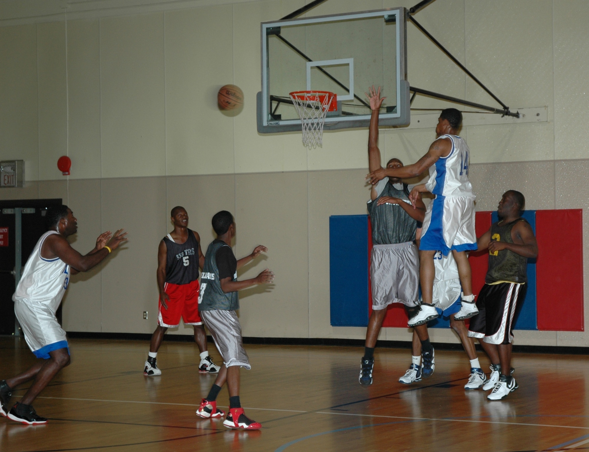 Malmstrom "A" guard Rafael Spears, #14, hands off to teammate forward Chalres Flanagan in early tournament action against the Moutain Home Gunfighters. Spears scored 12 of his 90 total tournament points in this game. He was later named the tournament most valuable player. (U.S. Air Force photo/Airman 1st Class Emerald Ralston)
