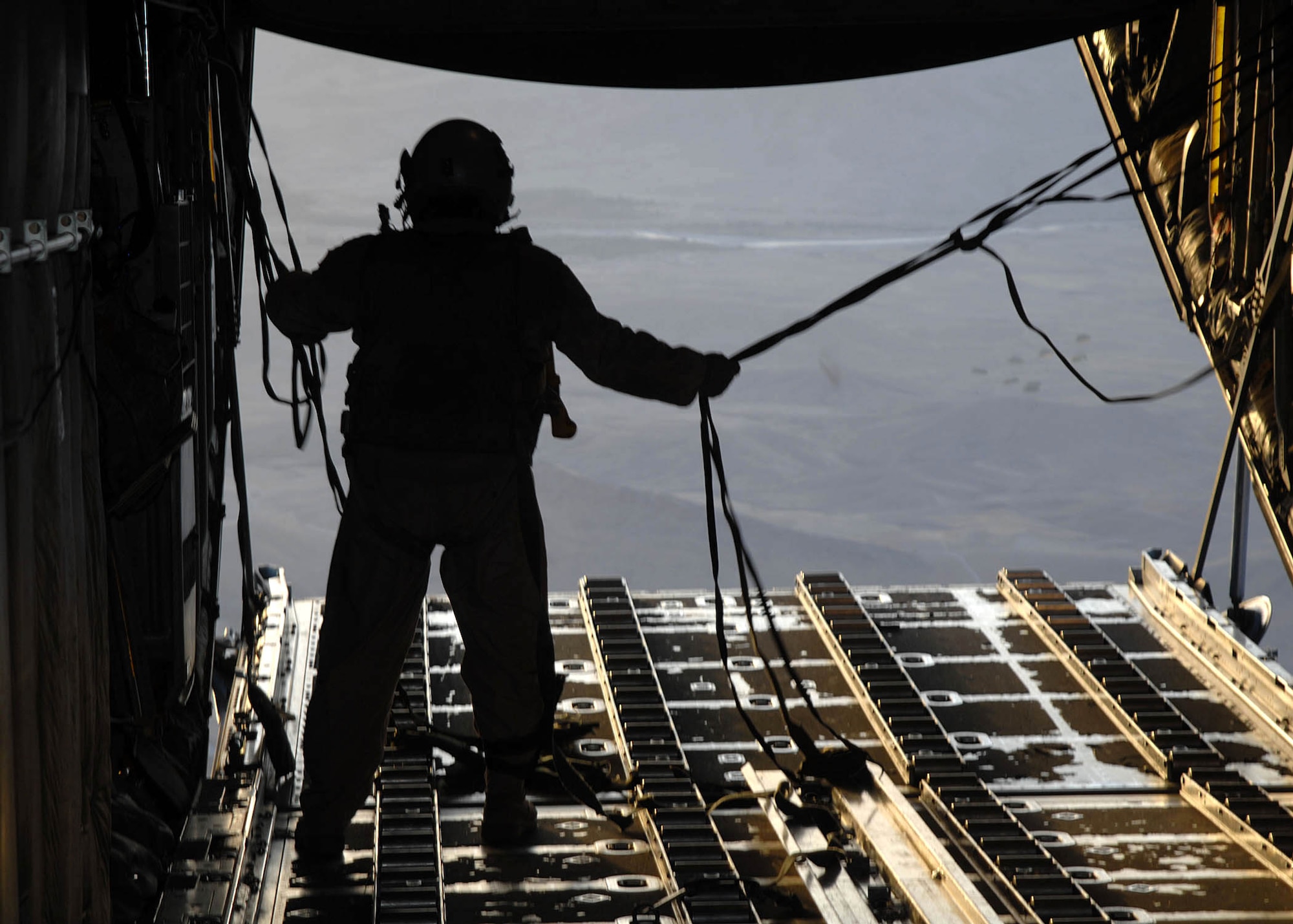 Senior Master Sgt. Roy Self cleans the ramp area after eight bundles of supplies were airdropped from a C-130 Hercules to troops in the field by the 774th Expeditionary Airlift Squadron from Bagram Air Base, Afghanistan. The airdrop crew are Air National Guard with the 165th Airlift Wing from Louisville, Ky., and the 109th Airlift Wing from Schenectady, N.Y. (U.S. Air Force photo/Senior Master Sgt. Kim Allain)
