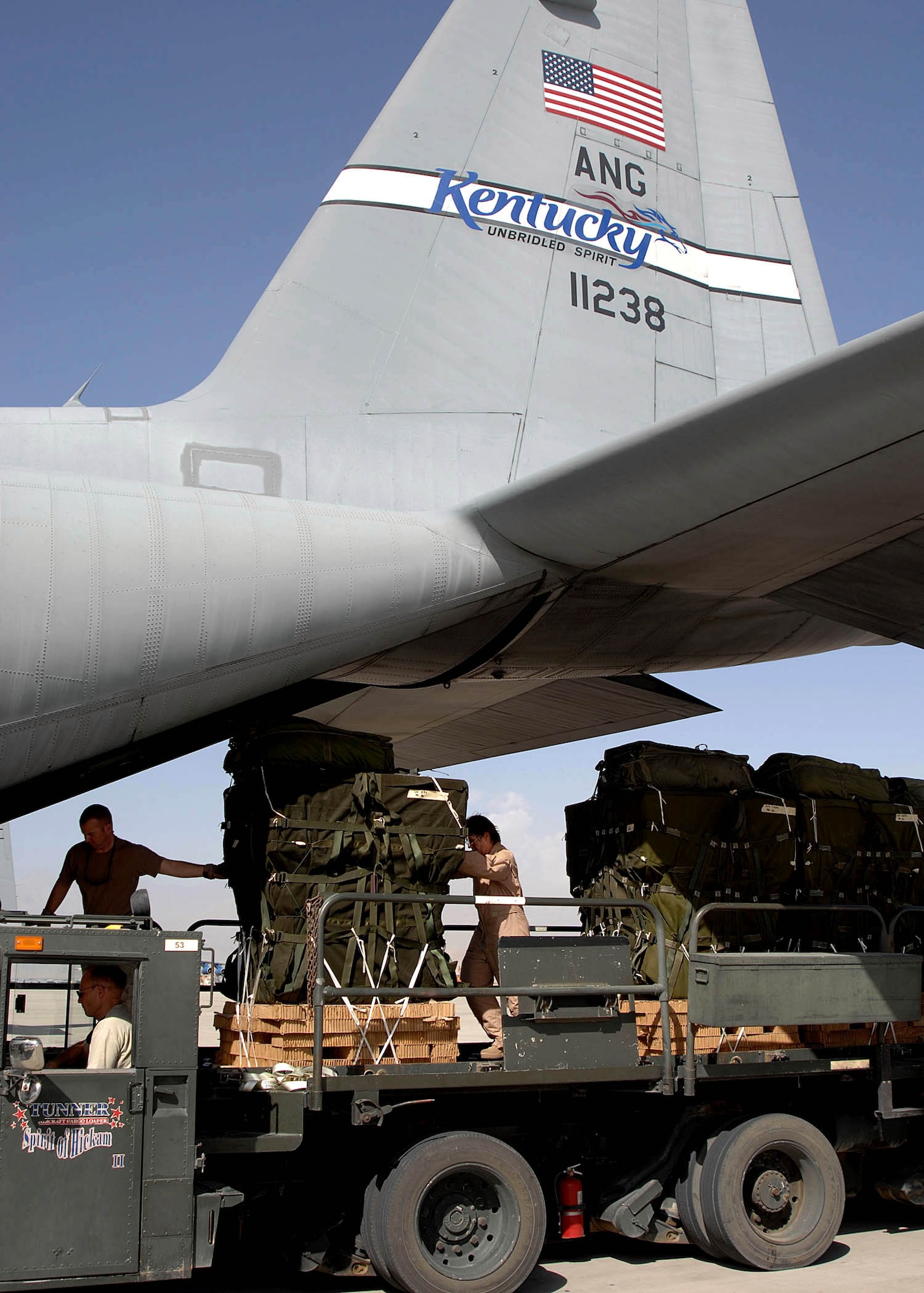 Aircrew members and rigging specialists load airdrop bundles off a K-loader onto a C-130 Hercules transport aircraft on the flightline at Bagram Air Base, Afghanistan. The members of the 774th Expeditionary Airlift Squadron transported the supplies to troops in the field. (U.S. Air Force photo/Senior Master Sgt. Kim Allain)
