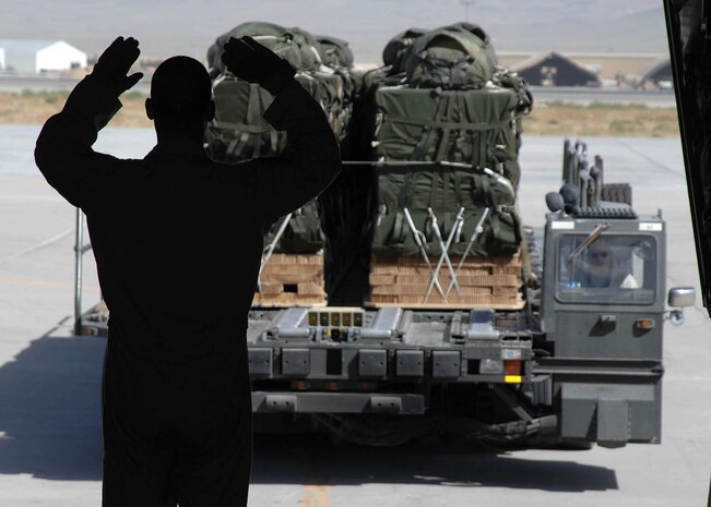 Tech. Sgt. Brad Simms guides a K-loader to the ramp of a C-130 Hercules to unload airdrop bundles being transported to troops in the field at Bagram Air Base, Afghanistan. Sergeant Simms is a joint airdrop inspector with the 774th Expeditionary Airlift Squadron. (U.S. Air Force photo/Senior Master Sgt. Kim Allain)