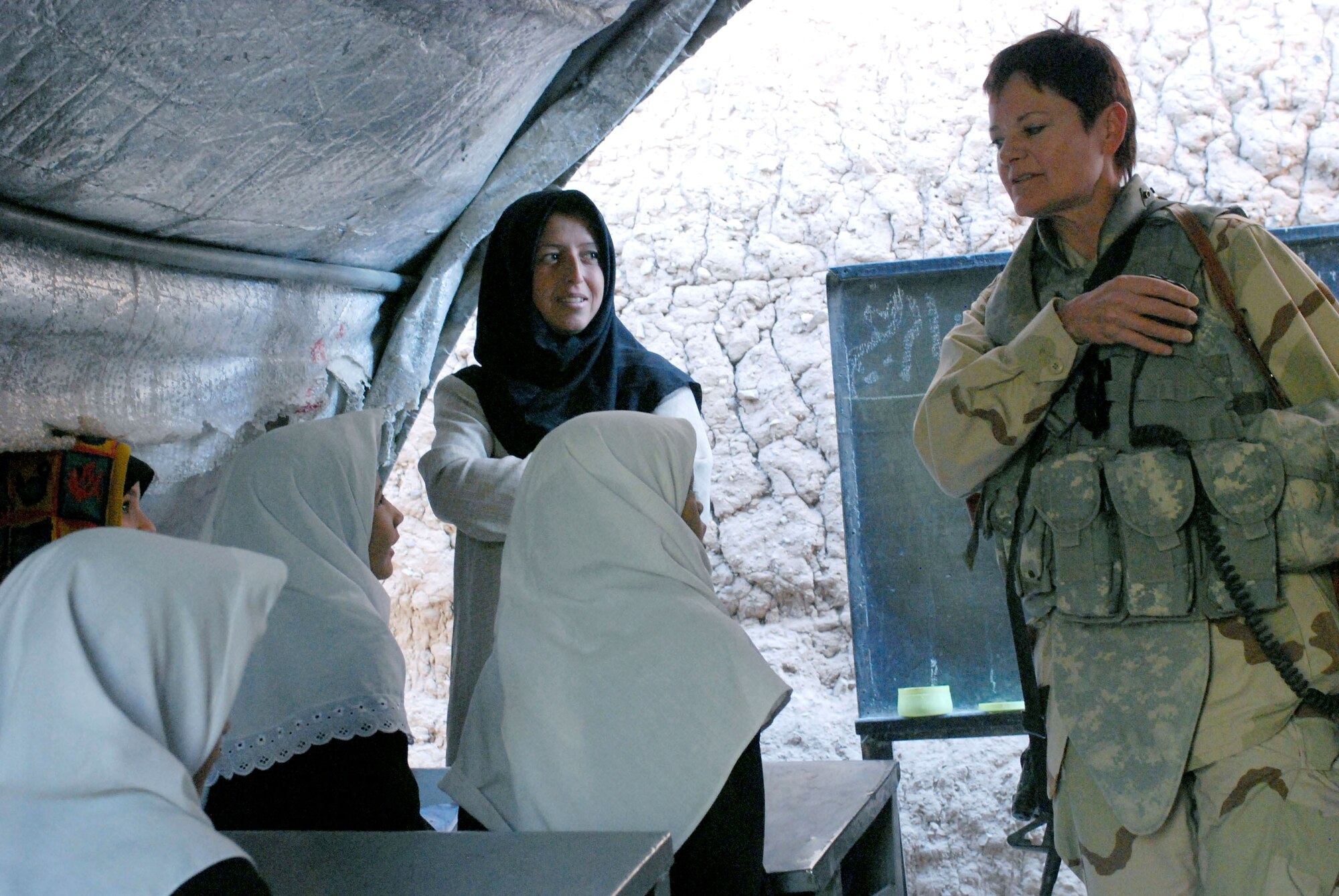 Navy Senior Chief Petty Officer Darlene Gonzales (right) talks with a school teacher and her students at an elementary school Sept. 29 in Herat, Afghanistan. Senior Chief Gonzales, a contracting team leader for the Afghan Regional Security Integration Command-West at Camp Stone in Herat, and nine other U.S. military women met with female teachers to drop off donated and requested supplies and to discuss ways coalition and the Afghan national security forces could be of assistance to the school and to Afghan women in general. (U.S. Marine photo/Staff Sgt. Luis P. Valdespino Jr.)
