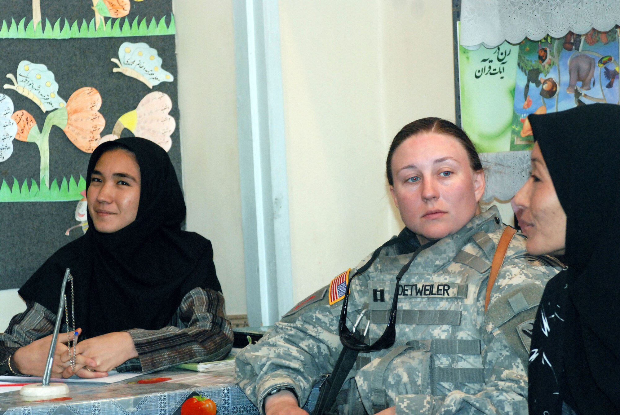 Army Capt. Megan S. Detweiler (center) listens as an Afghan teacher at an elementary school in Herat discusses issues of concern Afghan women are facing Sept. 29. Captain Detweiler, an information operations officer for Task Force Phoenix in Kabul, and nine other U.S. military women met with female teachers to drop off donated and requested supplies and to discuss ways coalition and the Afghan national security forces could be of assistance to the school and to Afghan women in general. (U.S. Marine photo/Staff Sgt. Luis P. Valdespino Jr.)
