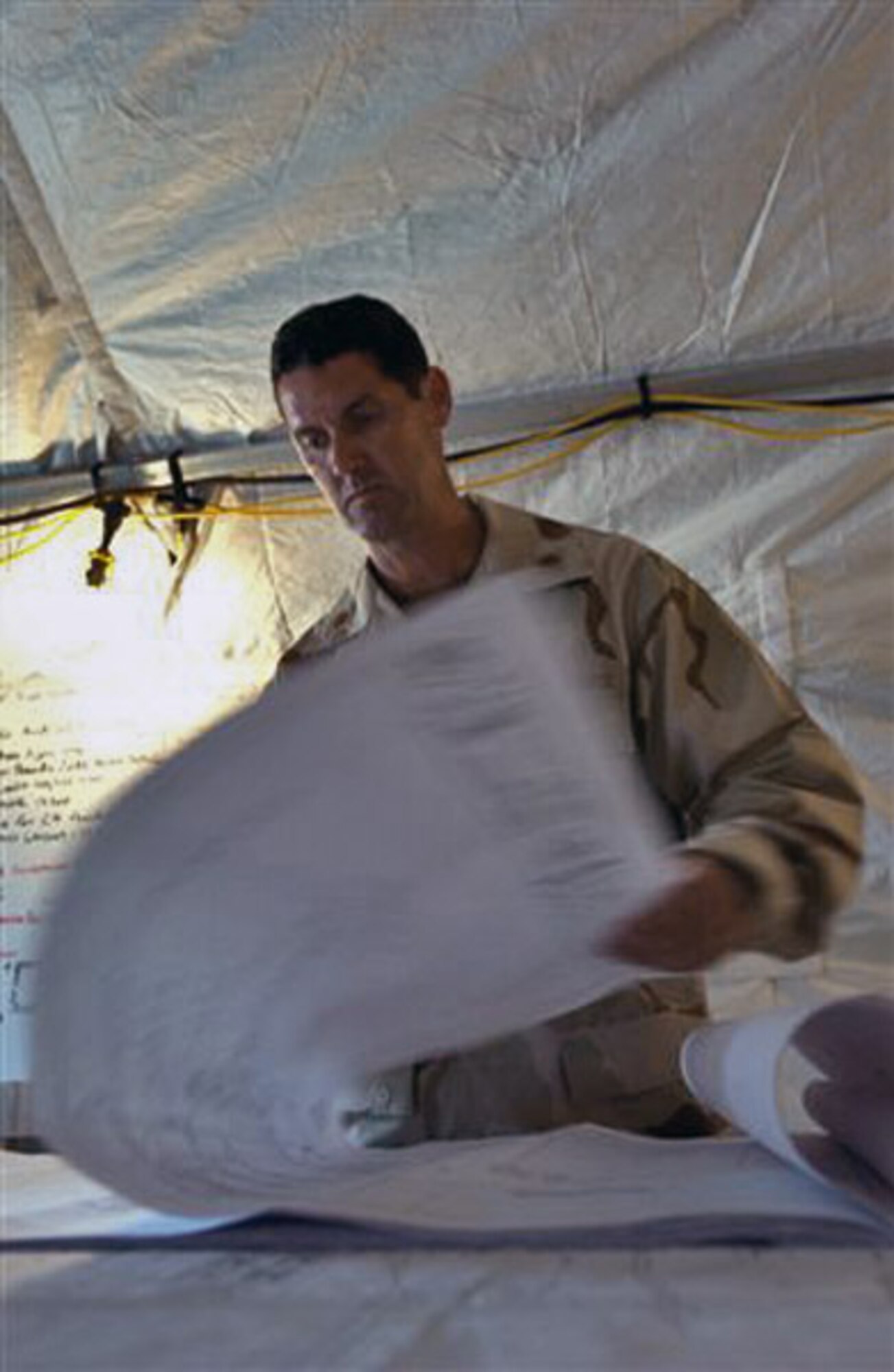 Maj. Chad Warren, 474th Expeditionary Civil Engineer Squadron, examines the plans Sept. 18 for the new expeditionary legal complex where military commissions will resume pending court review. The complex is expected to be completed early in early 2008. (U.S. Army photo/SGT. Sarah Stannard) 
