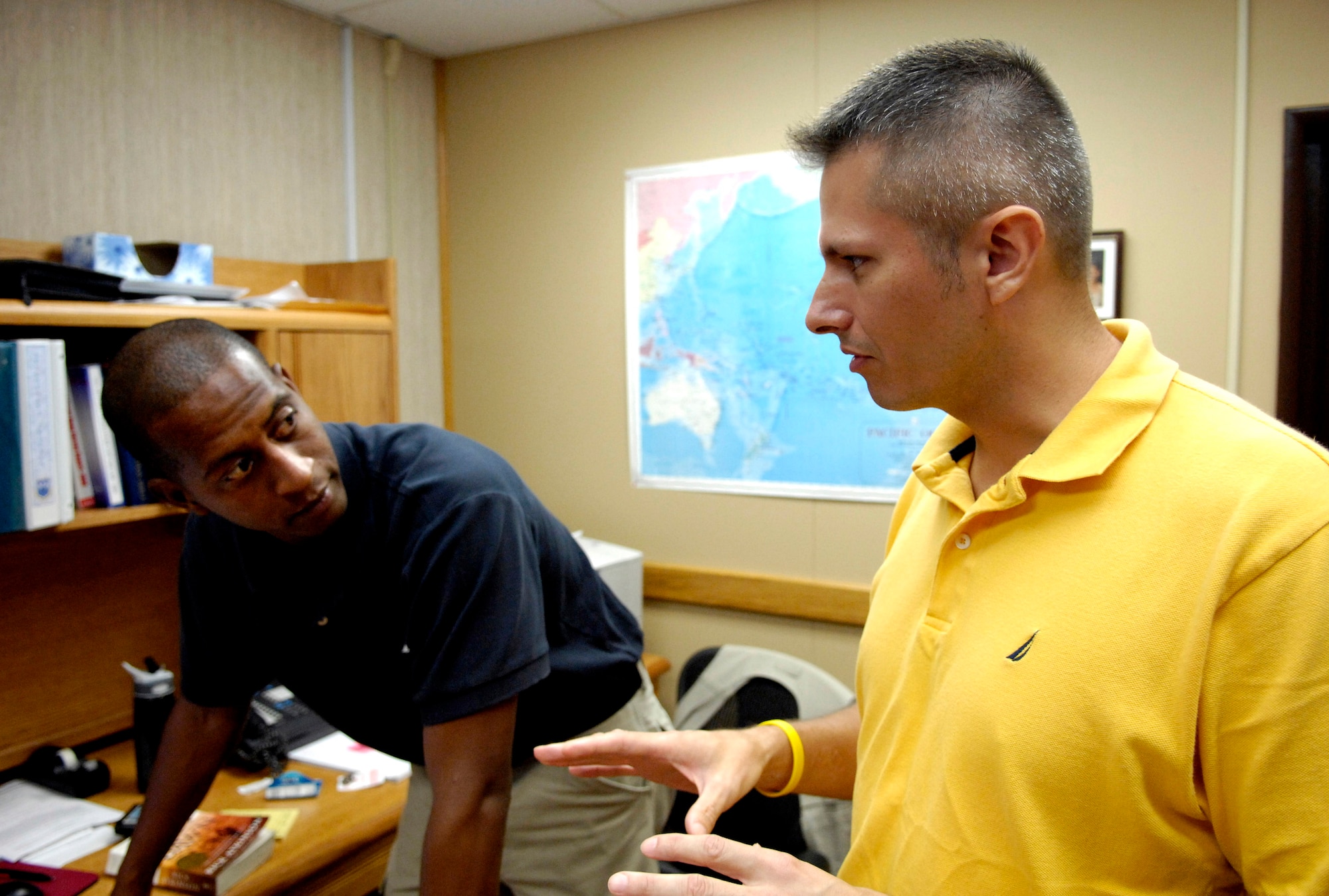 Special Agents Forrest Williams and Gregory Carmack discuss a case file Oct. 2 at Hickam Air Force Base, Hawaii. The Airmen are from the Air Force Office of Special Investigations Det. 601. Agent Carmack was recently awarded the Bronze Star with Valor for heroism in Iraq. (Air Force photo/Tech. Sgt. Shane Cuomo)
