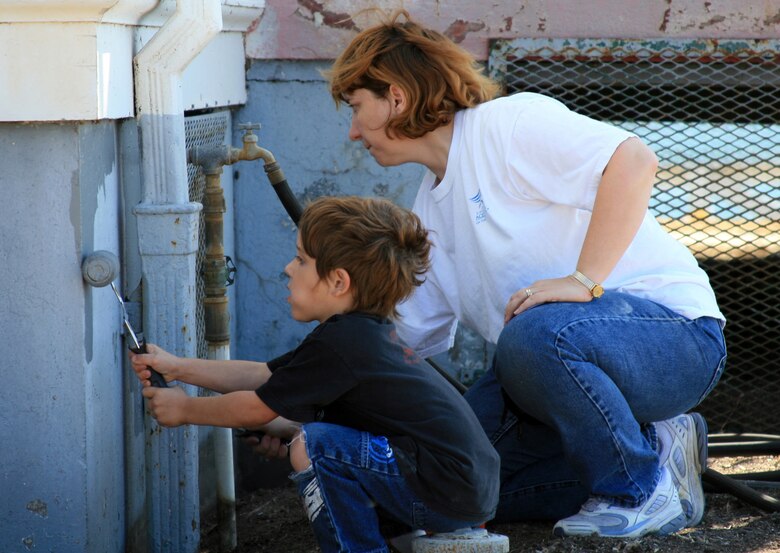 VANDENBERG AIR FORCE BASE, Calif.-- Kyle Young paints with his mom Master Sgt. Emily Young of the 30th Security Forces Squadron. Painting was just one of the many repairs that transpired at the boathouse on National Public Lands Day Sept. 29. (U.S. Air Force/Michael Peterson)