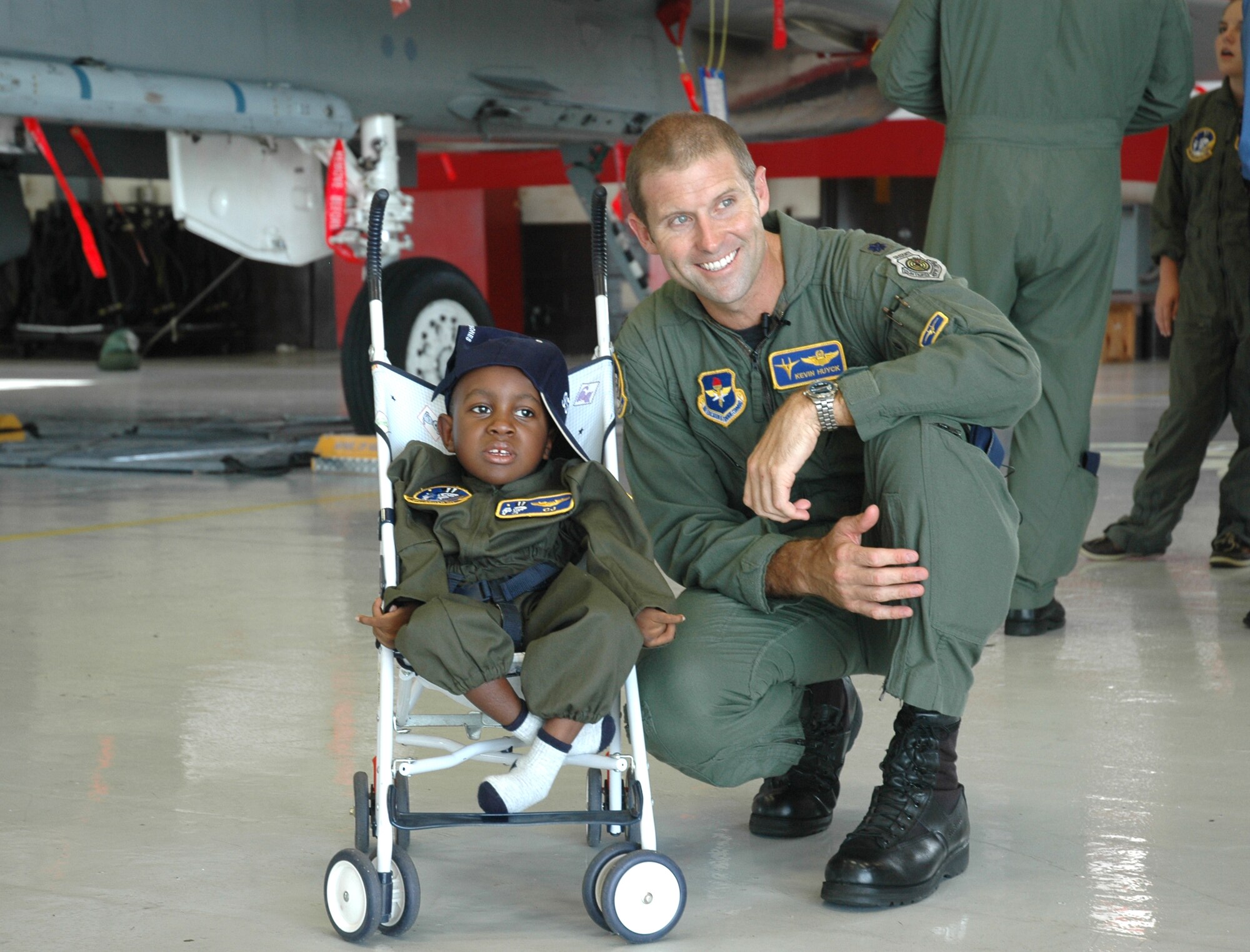 Lt. Col. Kevin Huyck, 95th Figther Squadron commander explores an F-15 with C.J. a participant in the Pilot for a Day program here Tuesday
