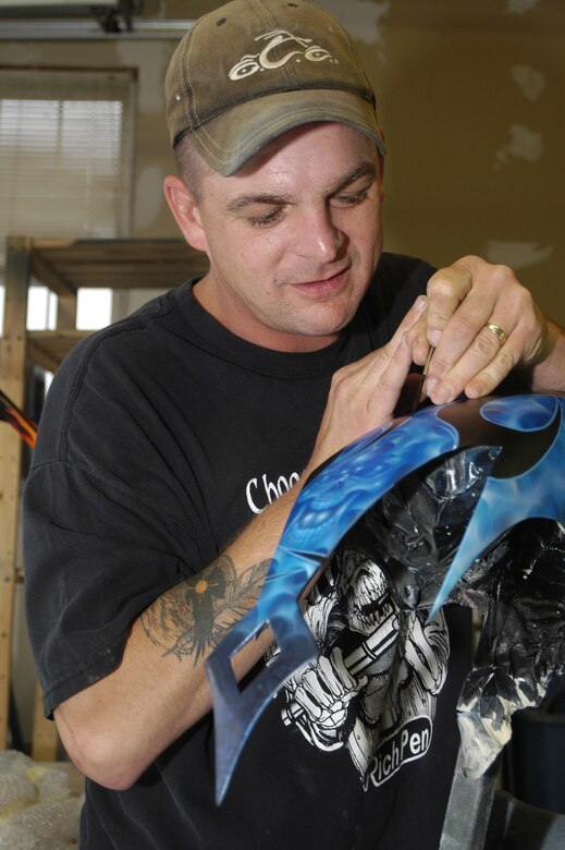 Staff Sgt. Randy Long, 436th Aerial Port Squadron, airbrushes a motorcycle hood. The project took about two weeks, 50 hours and 15 different colors to get the effects. Sergeant Long is an Airman by day and artisan by night. (U.S. Air Force photo/Airman Shen-Chia Chu)                             