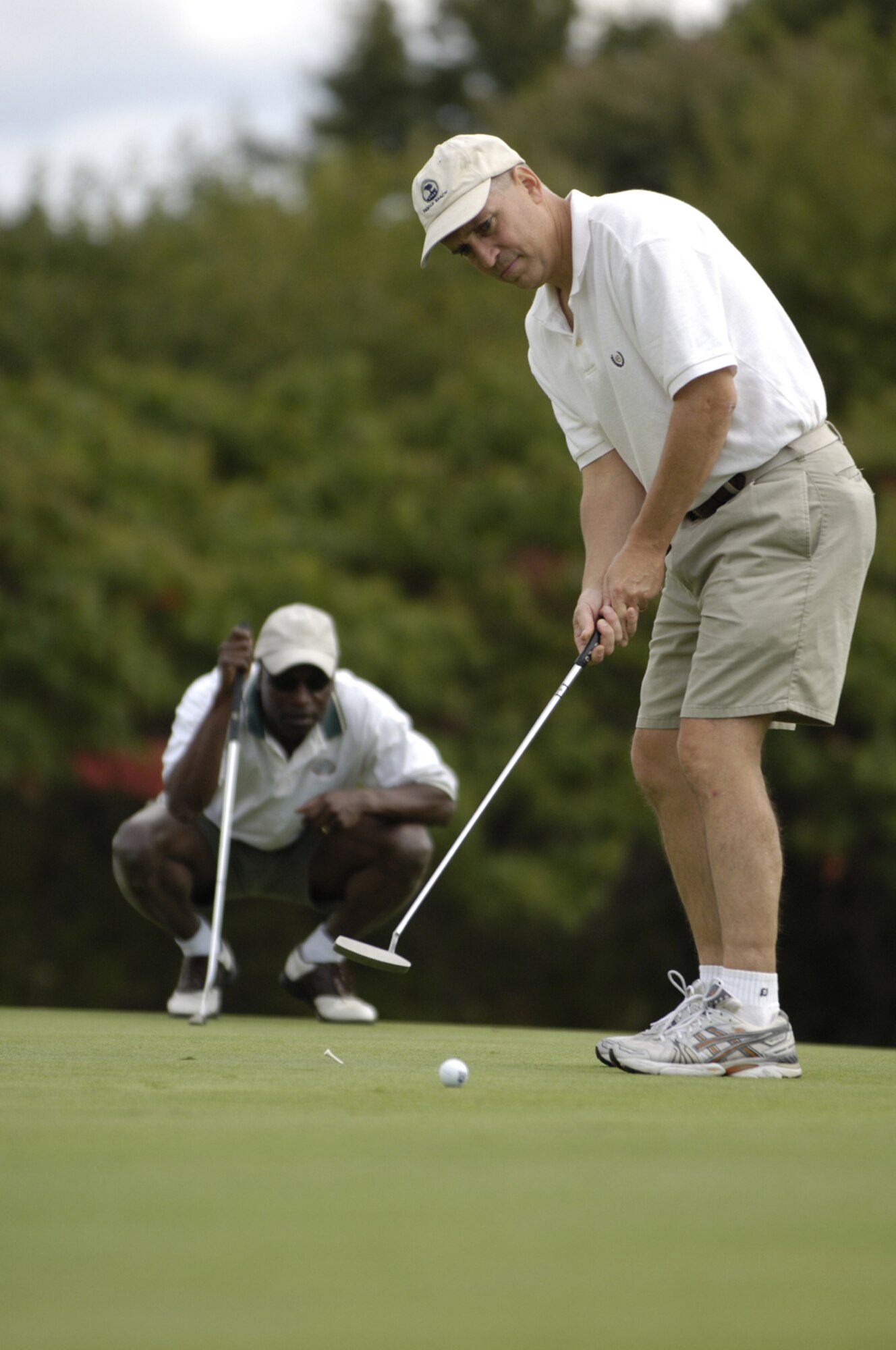 Col. Rick Martin, former 305th Air Mobility Wing commander, putts the ball toward the hole on the green as the Fort Dix commander, Col. Ronald R. Thaxton, watches during his farewell golf ceremony here Oct. 1. Team McGuire/Fort Dix personnel were invited to help say farewell to Colonel Martin before his departure for his new position overseas. Col. Balan Ayyar assumed command from Colonel Martin in a change-of-command ceremony here Oct. 2. (U.S. Air Force photo/Kenn Mann)