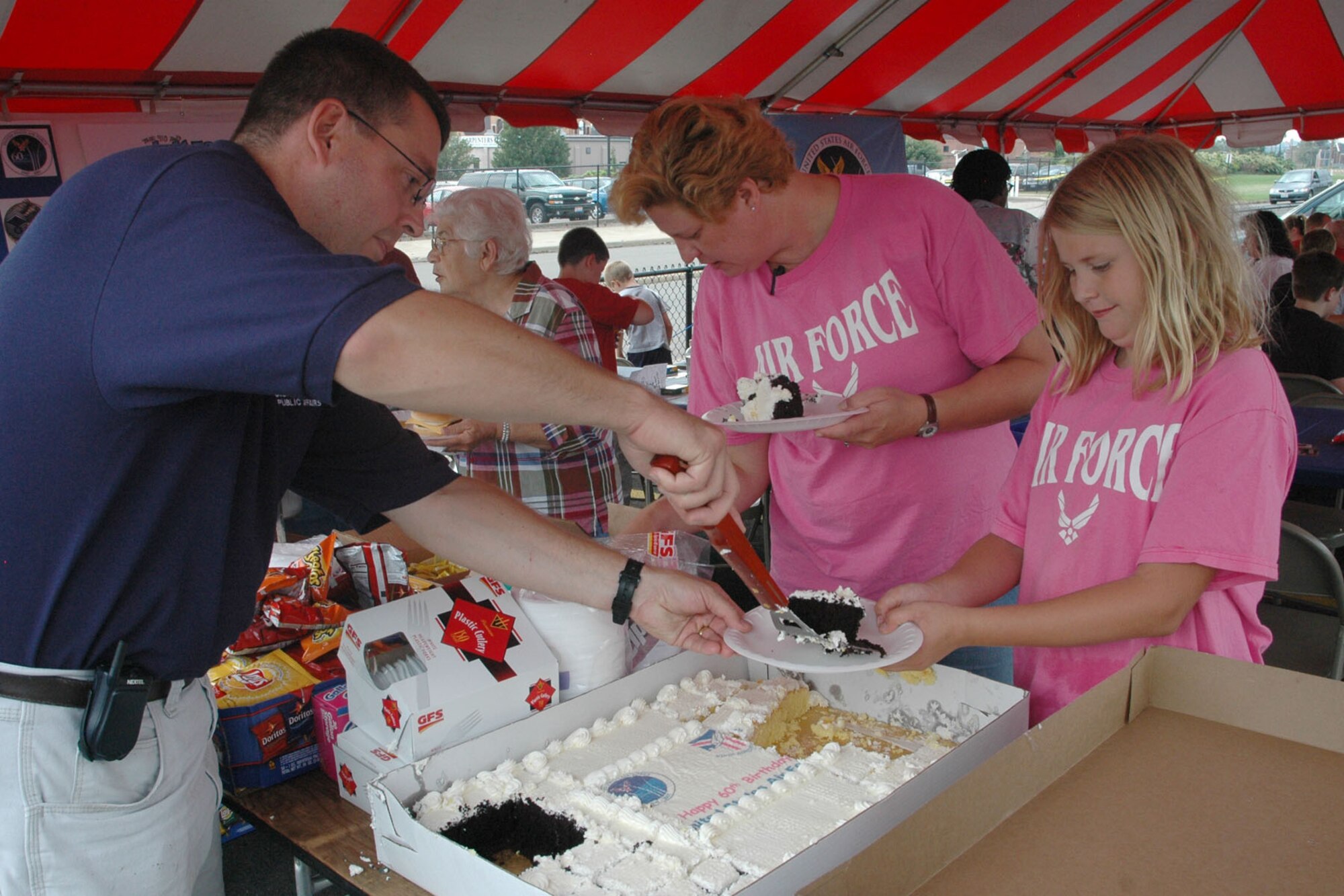 YOUNGSTOWN STATE UNIVERSITY, Ohio — Air Force Reserve Master Sgt. Bryan Ripple, Public Affairs Superintendent of the 910th Airlift Wing, serves a piece of cake to a guest at the wing hospitality tent as 370 Airmen, family members and friends from the 910th, based at Youngstown Air Reserve Station, attended a pre-game tailgate lot celebration and the home opener of Youngstown State University's 2007 football season in recognition of the U.S. Air Force's 60th birthday. U.S. Air Force photo/ Tech. Sgt. Bob Barko Jr. 