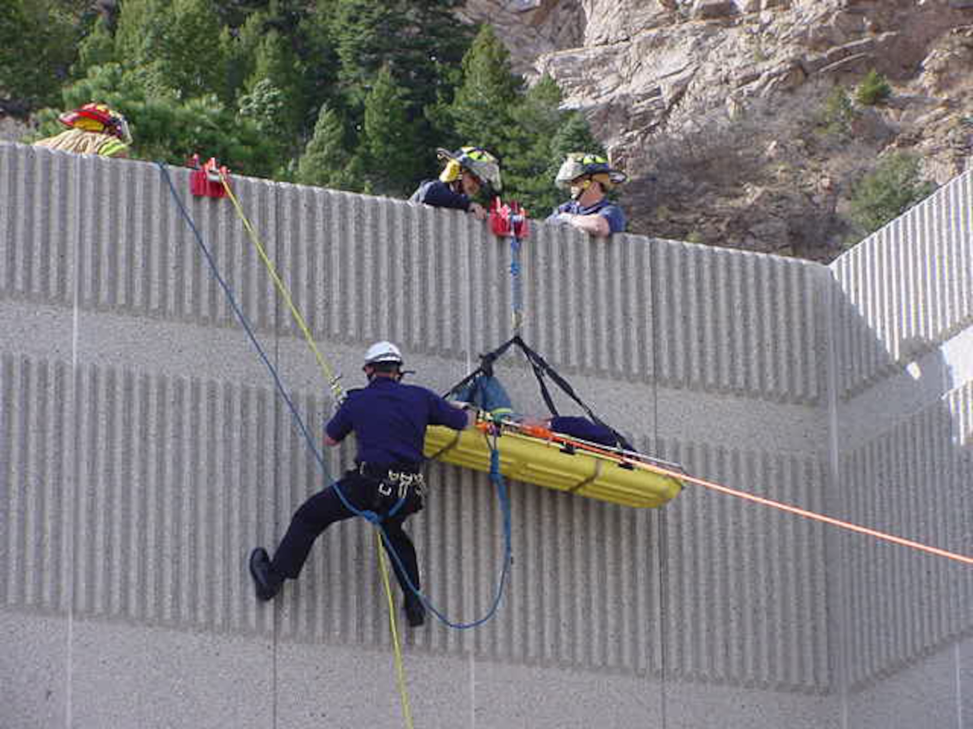 Firefighters at Cheyenne Mountain AFS rescue a man with a broken hip off the roof of a building. The man broke his hip while working on the roof in winds up to 75 mph. Cheyenne Mountain’s fire department often responds to calls related to the mountain’s erratic weather, from high winds to large snow storms. (U.S. Air Force photo)