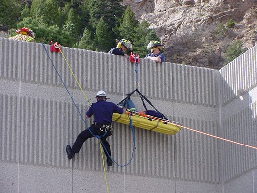 Firefighters at Cheyenne Mountain AFS rescue a man with a broken hip off the roof of a building. The man broke his hip while working on the roof in winds up to 75 mph. Cheyenne Mountain’s fire department often responds to calls related to the mountain’s erratic weather, from high winds to large snow storms. (U.S. Air Force photo)