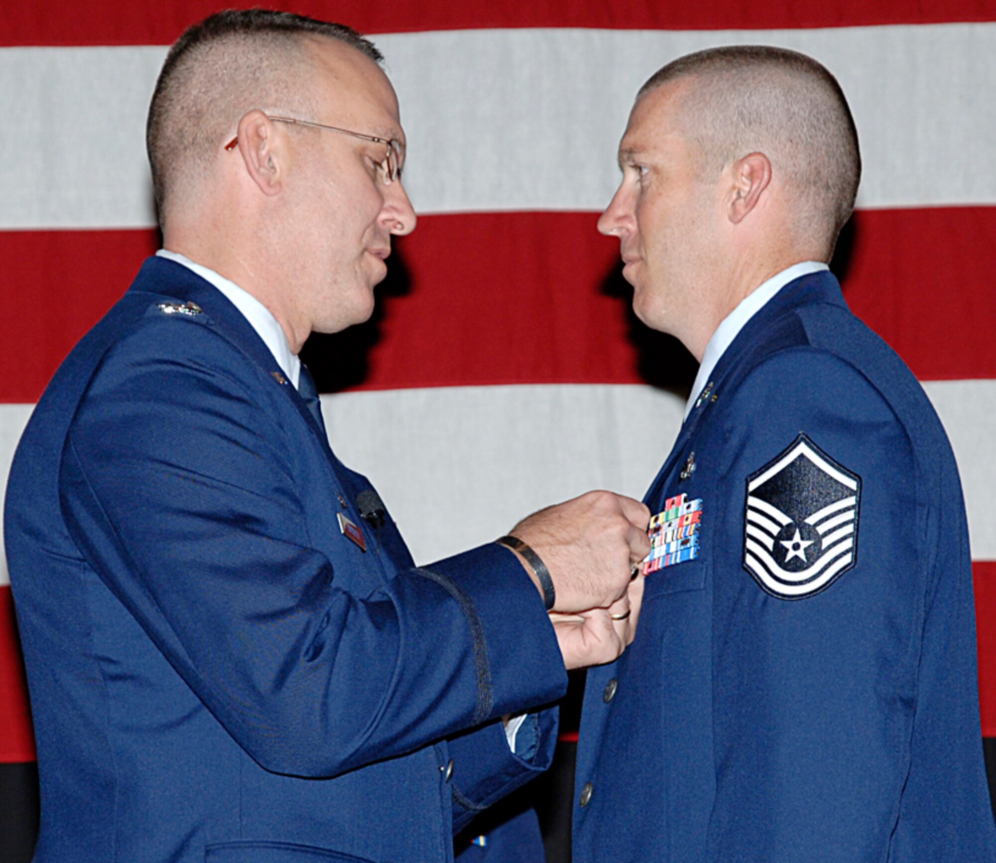 Col. Ray LaMarche, 22nd Operations Group commander, pins a bronze star on Master Sgt. Timothy Waggoner, 22nd Logistic Readiness Squadron, during a promotion ceremony Sept. 28 at the Robert J. Dole Center ballroom. (Photo by Airman 1st Class Roy Lynch III.)