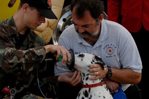 Airman 1st Class Aaron Rogers, 1st Civil Engineer Squadron firefighter, and Mr. Bill Sorrell, 1st CES emergency communications center supervisor, demonstrate how to administer oxygen to Blaze using Langley's newly purchased pet oxygen masks. The Langley and Bethel Fire Departments will be out and about providing information on fire prevention Oct. 7-13, which is National Fire Prevention Week. (U.S. Air Force photo/Senior Airman Christopher L. Ingersoll)