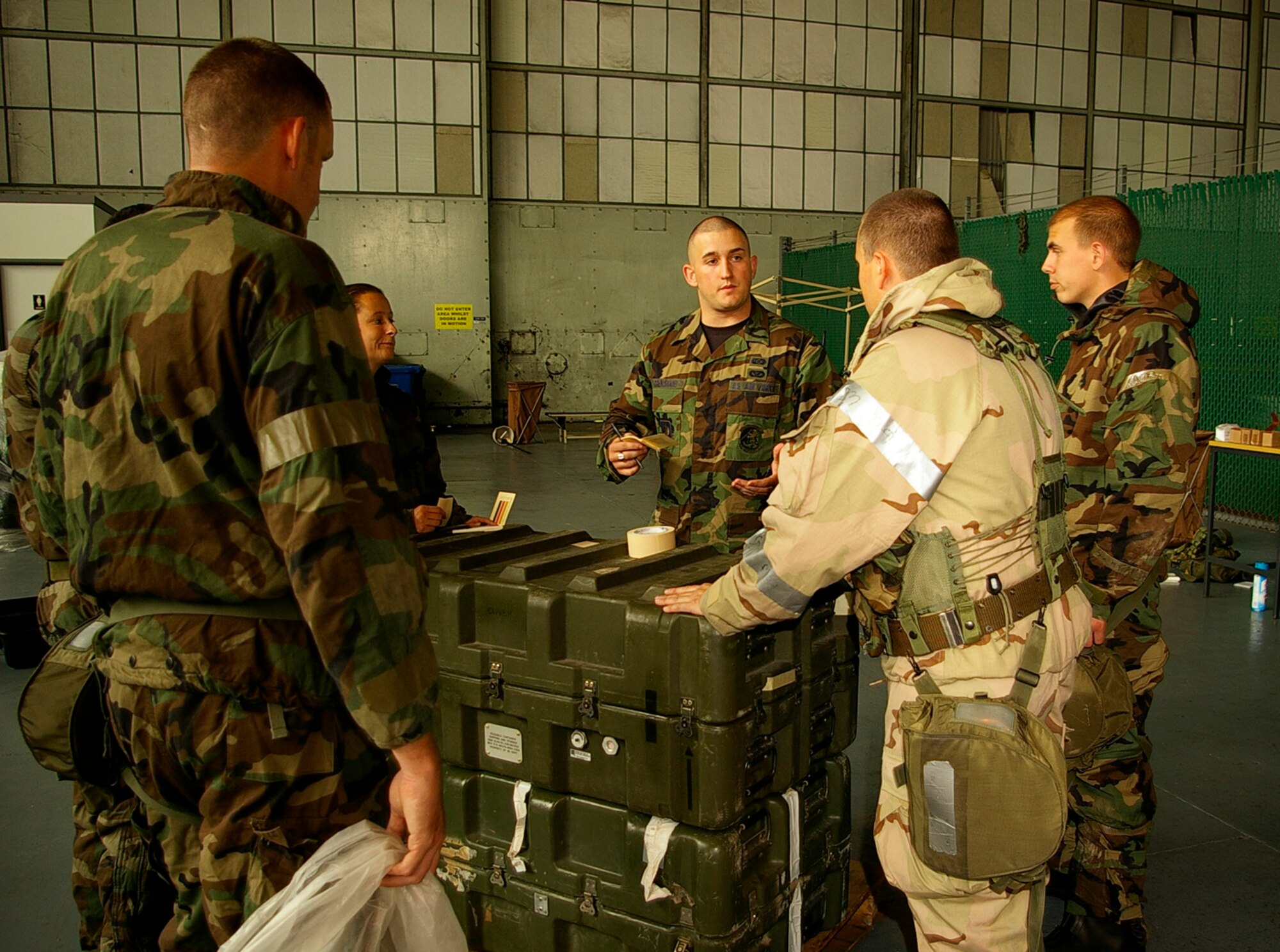 Airman 1st Class Thomas Crenshaw, 100th Civil Engineer Squadron Readiness and Emergency Management Flight, evaluates students as they prepare to put M9 paper, chemical detection paper, on assets being covered during CBRN survival skills training Sept. 6. (U.S. Air Force photo by Karen Abeyasekere)