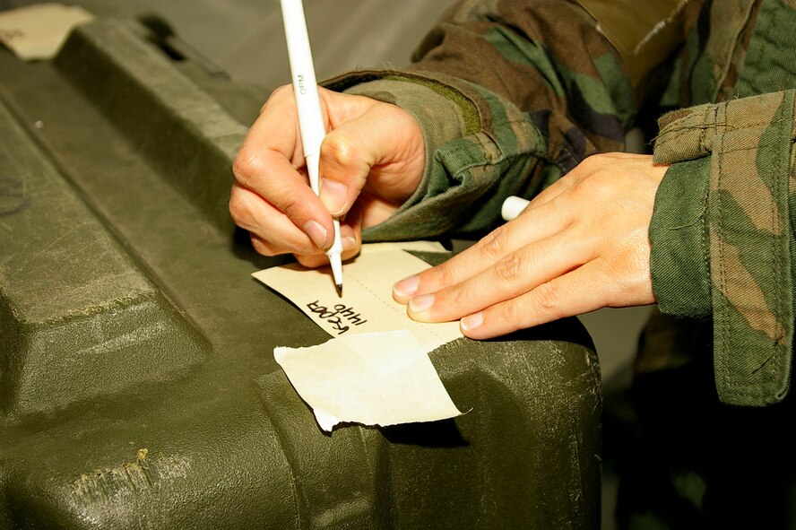 Staff Sgt. Christopher Wynn, left, 352nd Maintenance Squadron, and Tech. Sgt. Ronda Betterton, 100th Security Forces Squadron, inspect M8 chemical detection paper, to see if it has changed color, during hands-on training at Building 538 Sept. 6. (U.S. Air Force photo by Karen Abeyasekere)