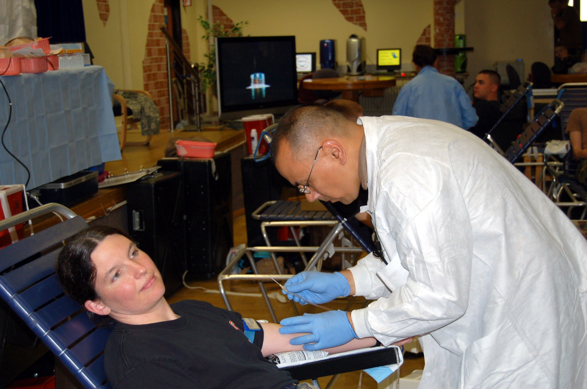 SPANGDAHLEM AIR BASE, Germany – Navy Petty Officer 1st Class Brian King, Landsthul Regional Medical Center, prepares to insert a needle into the arm of Tech. Sgt. Shara Lewis, 52nd Logistics Readiness Squadron. During the Spangdahlem Air Base blood drive, Sabers donated 64 units of blood. (U.S. Air Force photo/Staff Sgt. Tammie Moore)