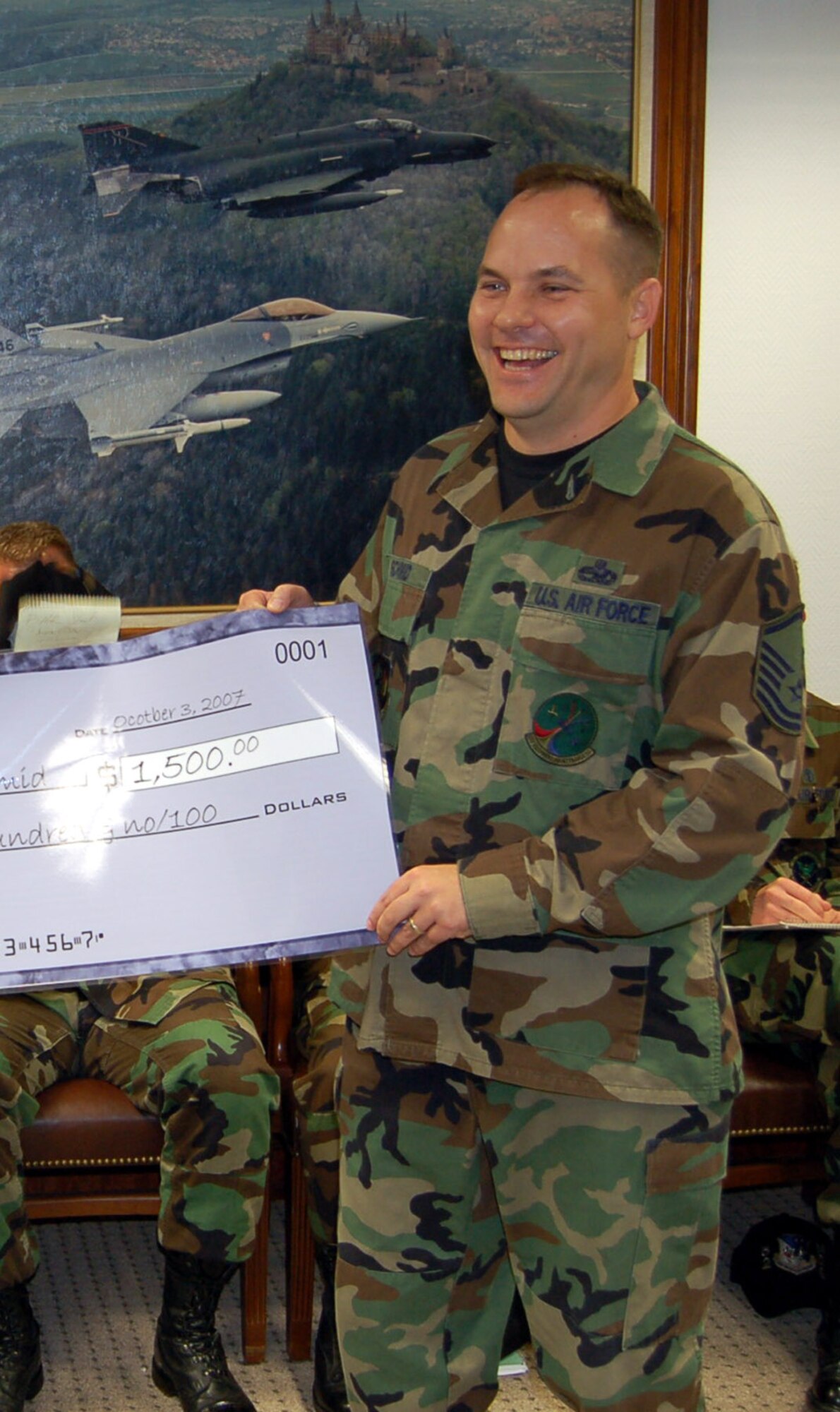 SPANGDAHLEM AIR BASE, Germany -- Master Sgt. Karl Schmid, 52nd Equipment Maintenance Squadron, happily accepts an Extreme Summer check for $1,500 Oct. 3. Sergeant Schmid won the prize through the Extreme Summer USAA Summer Sweepstakes. For more information about the Extreme Summer program, visit www.extremesummer.com/home.aspx. (U.S. Air Force photo/Capt. Kevin Coffman) 