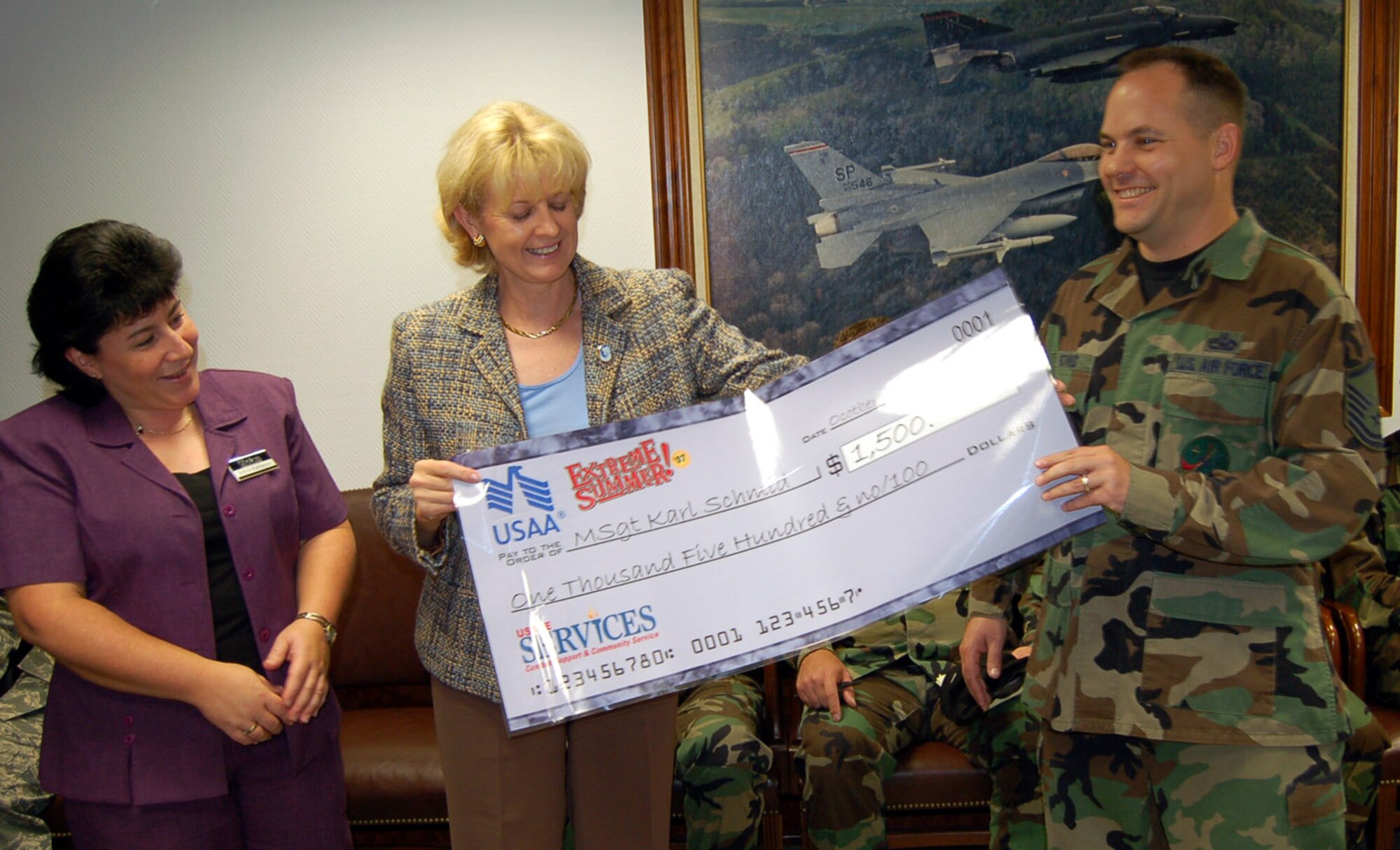 SPANGDAHLEM AIR BASE, Germany -- Master Sgt. Karl Schmid, 52nd Equipment Maintenance Squadron, is presented with an Extreme Summer check for $1,500 by (left to right) Sylvia Ramseyer, U.S. Air Forces in Europe Services, and Audrey Thompson, USAA, Oct. 3. Sergeant Schmid won the prize through the USAA Summer Sweepstakes. For more information about the Extreme Summer program, visit www.extremesummer.com/home.aspx. (U.S. Air Force photo/Capt. Kevin Coffman) 