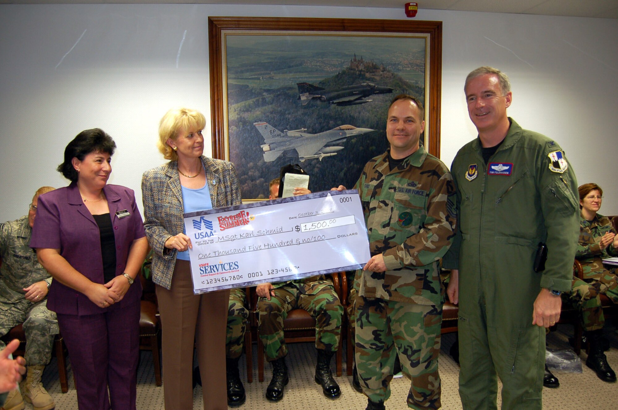 SPANGDAHLEM AIR BASE, Germany -- Master Sgt. Karl Schmid, 52nd Equipment Maintenance Squadron, is presented with an Extreme Summer check for $1,500 by (left to right) Sylvia Ramseyer, U.S. Air Forces in Europe, Audrey Thompson, USAA, and Col. Thomas Feldhausen, 52nd Fighter Wing vice commander Oct. 3. Sergeant Schmid won the prize through the USAA Summer Sweepstakes. For more information about the Extreme Summer program, visit www.extremesummer.com/home.aspx. (U.S. Air Force photo/Capt. Kevin Coffman) 