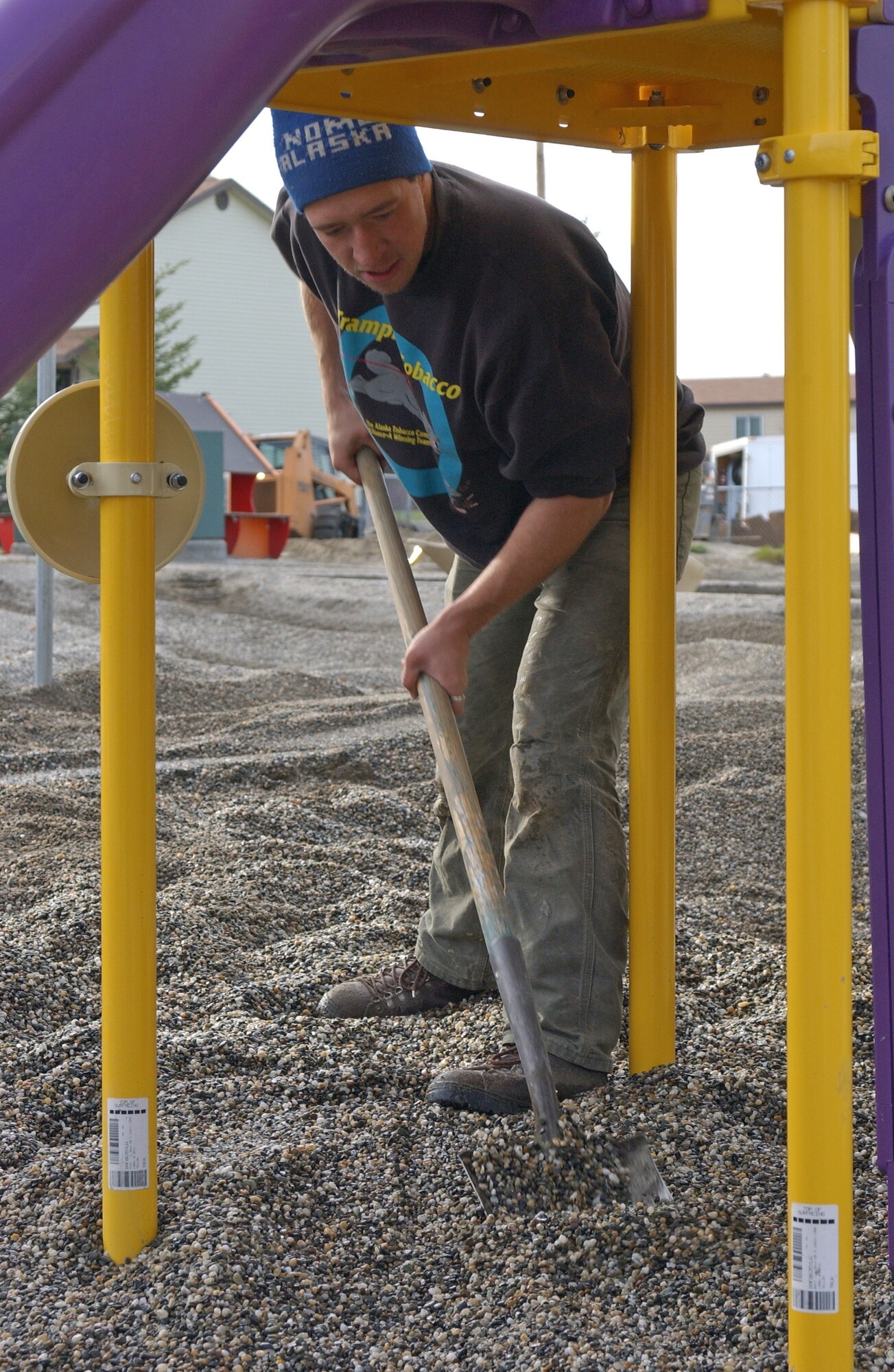 EIELSON AIR FORCE BASE, Alaska--Adam Kelley, Trost Construction employee, spreads rocks underneath new playground equipment Oct. 5 at the Child Development Center. The old playground was torn out Aug. 23 to be replaced by newer equipment for the children. The playground is expected to be finished within two weeks. (U.S. Air Force photo by Airman 1st Class Nora Anton)                              