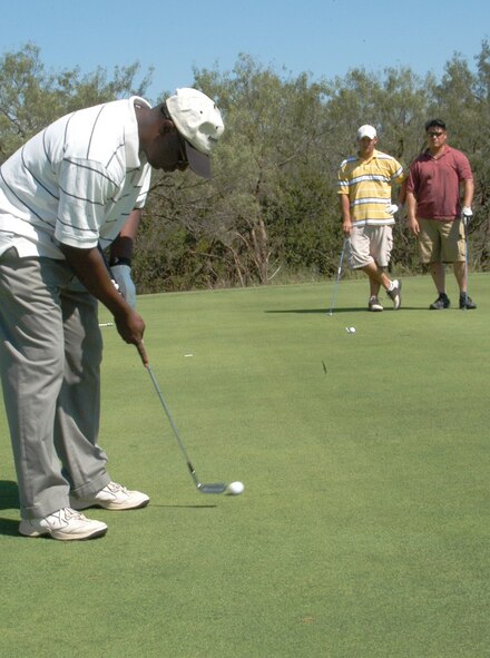 DYESS AIR FORCE BASE, Texas -- Jeff Blackman putts on the 11th hole during the Busted Putter golf tournament with Abilene leadership at the Mesquite Grove Golf Course Oct. 5. Looking on are 7th Munitions Squadron coworkers Brandon Lee and Jay Jacobs. (U.S. Air Force photo by Senior Airman Carolyn Viss