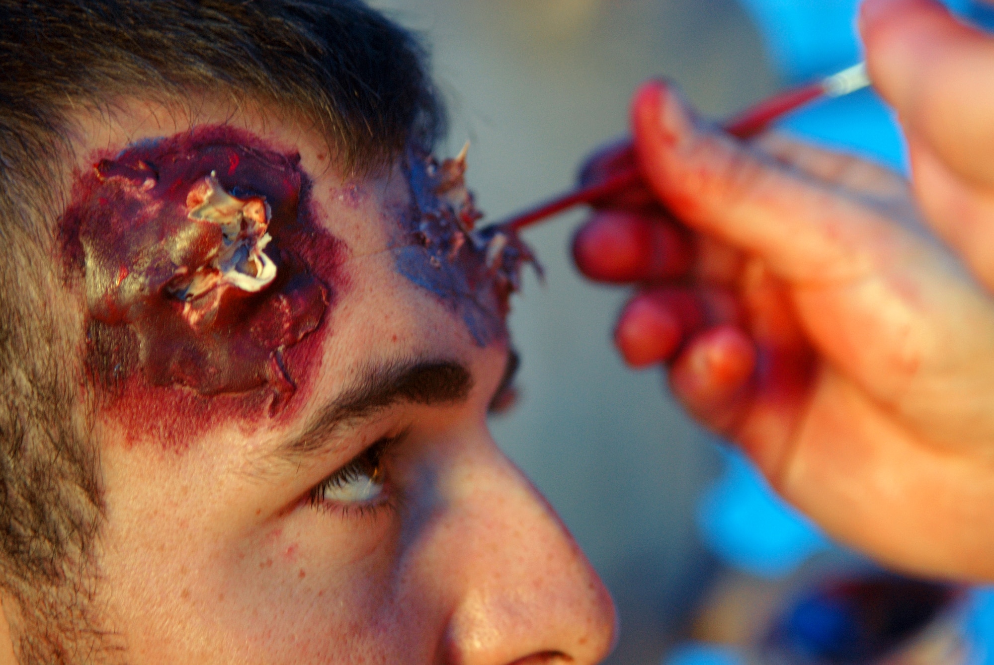 2nd Lt. Brian Leen from the 315th Training Squadron has moulage makeup applied to his face to simulate an injury during the off-base MARE Sept. 20. Students from Goodfellow portrayed injured airplane passengers as well as members of the media during the exercise, designed to test the working relationship between Goodfellow and the City of San Angelo. (U.S. Air Force photo by Airman 1st Class Kamaile Chan)