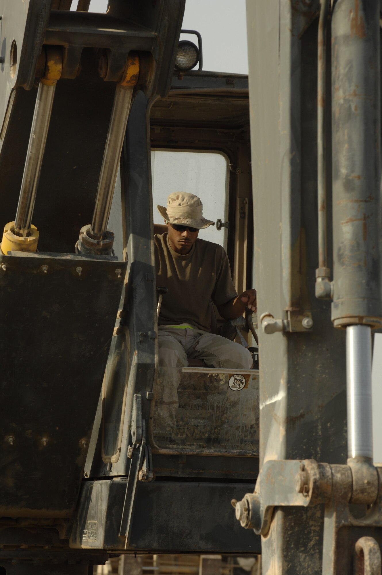 Staff Sgt. Virginio Rivera operates an excavator that is digging a trench Oct. 3 for concrete footers for sun shades being installed on the Ali Base, Iraq, flightline.  Airman Davis and other Airmen in the 407th Civil Engineer Squadron are working around the clock to build the sun shades by November.  (U.S. Air Force photo/Airman 1st Class Jonathan Snyder) 