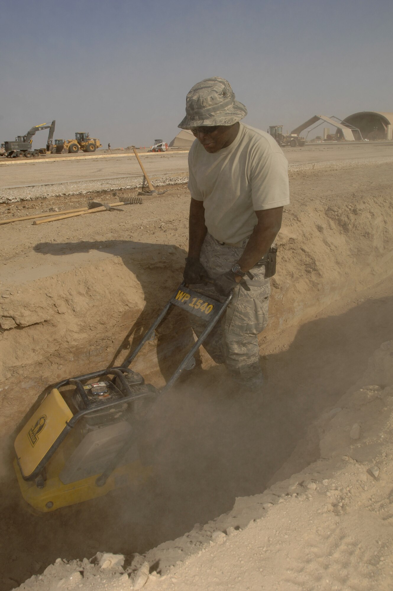 Staff Sgt. Reginald Colbert uses a tamper to compact the ground in preparation to pour concrete Oct. 3 at Ali Base, Iraq. Sergeant Colbert and other Airmen in the 407th Civil Engineer Squadron are working around the clock to build several sun shades on the flightline by November.  (U.S. Air Force photo/Airman 1st Class Jonathan Snyder) 