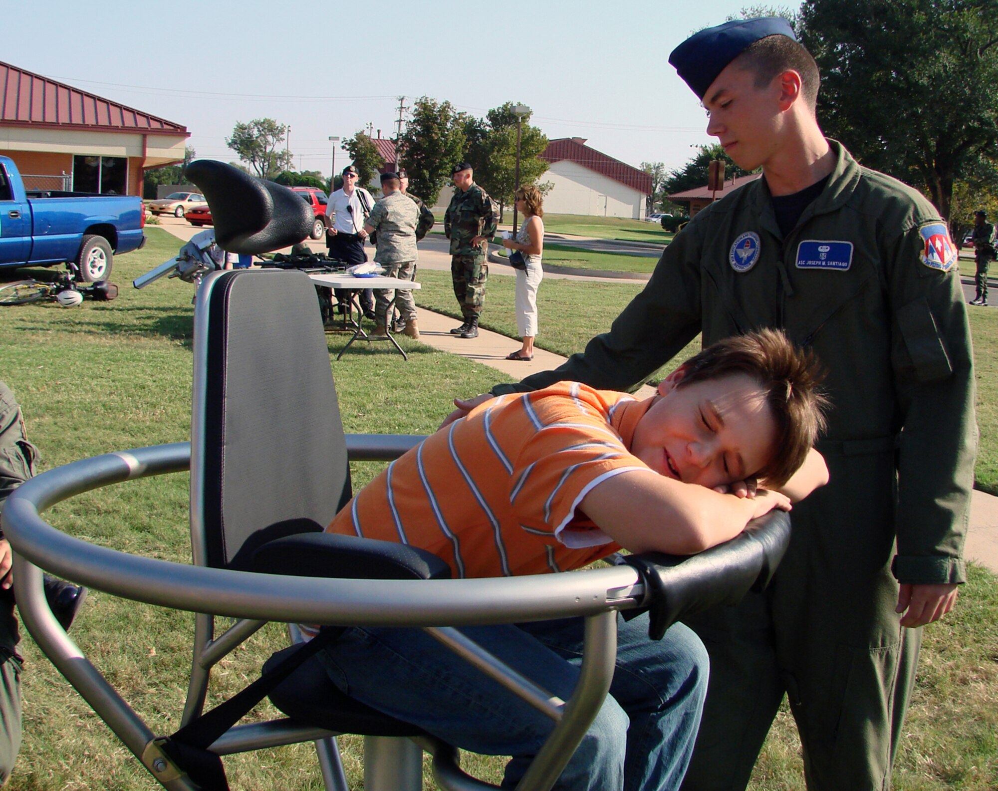 Airman 1st Class Joseph Santiago, an Aerospace Physiology technician (right), gives Sean Curry, 12, a spin in a Barany Chair at Fall Fest 2007 at the Vance Youth Center Oct. 4. The chair teaches student pilots about spatial disorientation.  Sean is the son of Heather and Navy Cmdr. Roger Curry, 8th Flying Training Squadron director of operations. (U.S. Air Force photo by Tech. Sgt. Mary Davis)                    