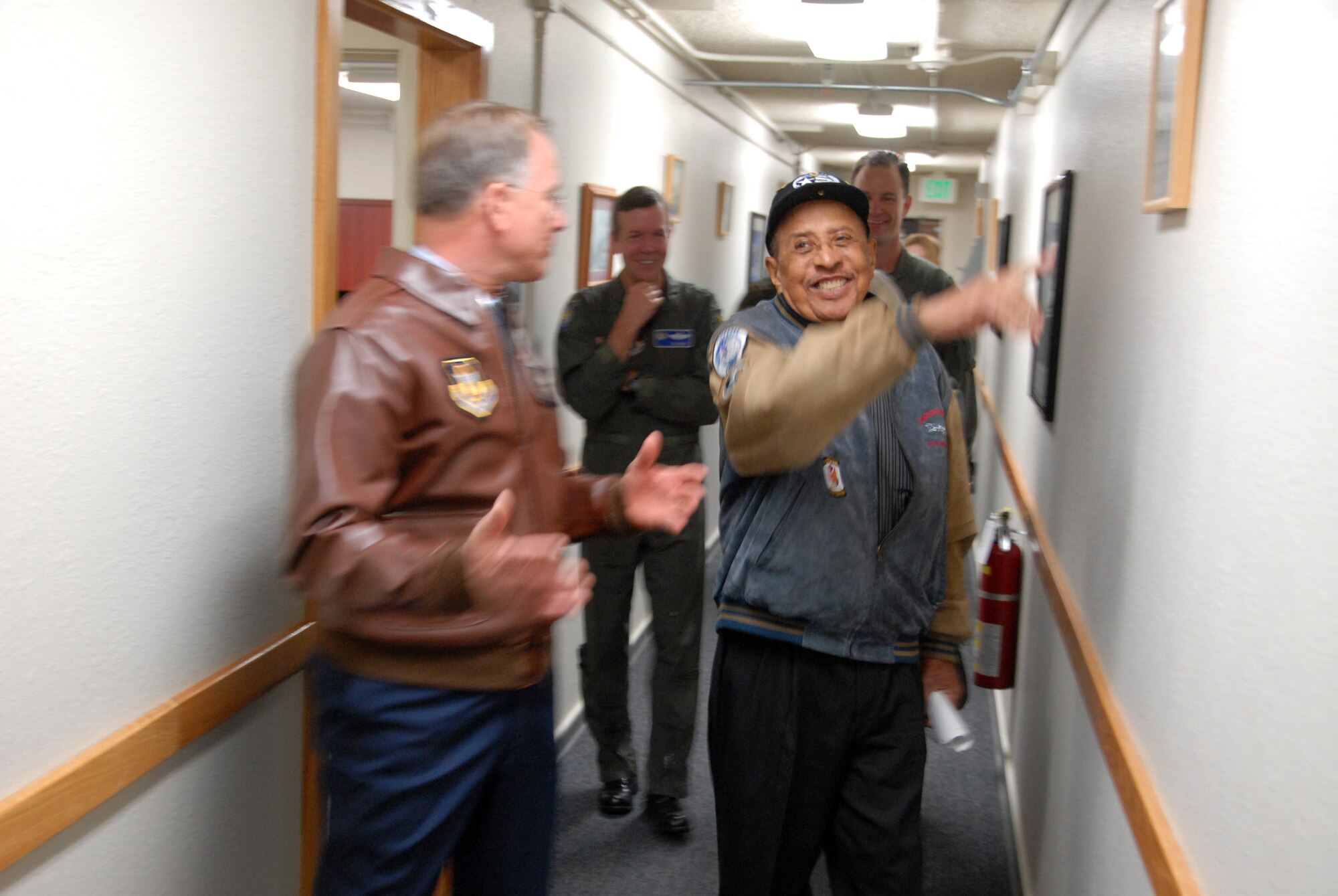 Retired Lt. Col. James Warren takes a walk down memory lane with Lt. Gen. John A. Bradley, remeniscing over historical photos that line the walls of the new 477th Fighter Group Headquarters at Elemendorf Air Force Base, Alaska. The newly designated unit is tied historically to the Tuskegee Airmen. Colonel Warren, an original Tuskegee Airmen, describes in great detail each photo and the hardships they endured. General Bradley is the chief of the Air Force Reserve Command. (U. S. Air Force photo/Master Sgt. Chance Babin)