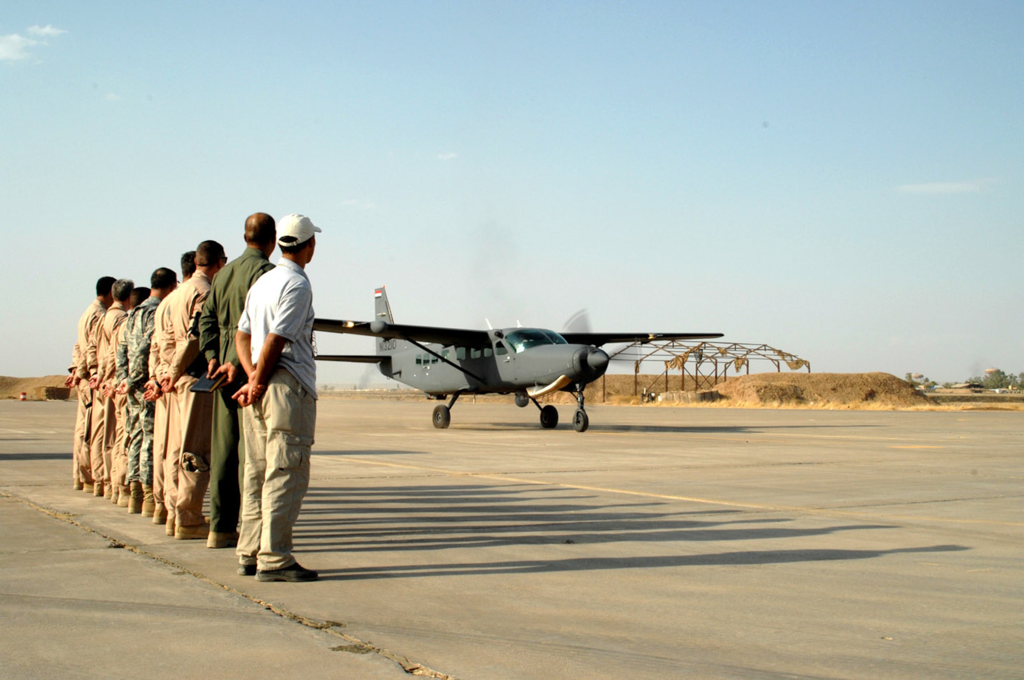 Members of the 52nd Flying Training Squadron stand in formation as the first students arrive Oct. 1 to the Iraqi air force flying training school at Kirkuk Air Base, Iraq. This flight was officially the first sortie flown by the school as the four Iraqi air force students took control of the aircraft for a few minutes in transit to see what it is they are working toward. The school will instruct the students in both fixed- and rotary-wing piloting. (U.S. Air Force photo/Senior Airman Jeremy McGuffin) 
