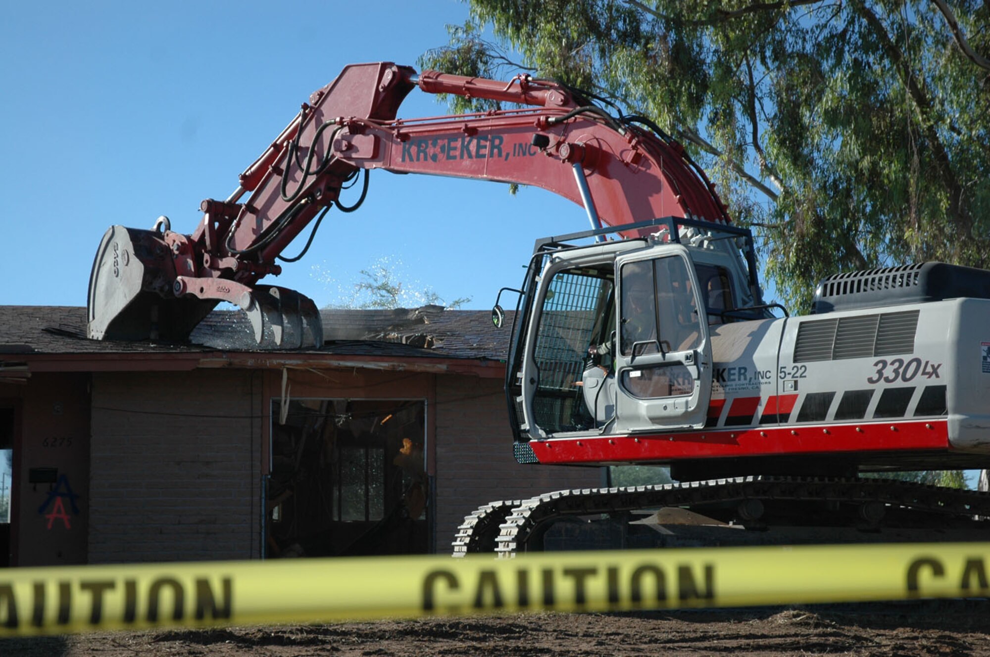 Colonel Kent Laughbaum, 355th Fighter Wing commander, uses an excavator to demolish the first home being replaced as part of the $300 million privatized housing improvements here Oct. 5. This demolition marked the first of 868 old housing units scheduled to be demolished to make way for more than 500 new homes being constructed as part of the multi-million dollar privatization project. The new homes will feature state-of-the-art ENERGY STAR appliances, home office space with technology niches, covered porches for integrated indoor/outdoor living and spacious master bedroom suites. (U.S. Air Force photos by Staff Sgt. Tim Beckham)