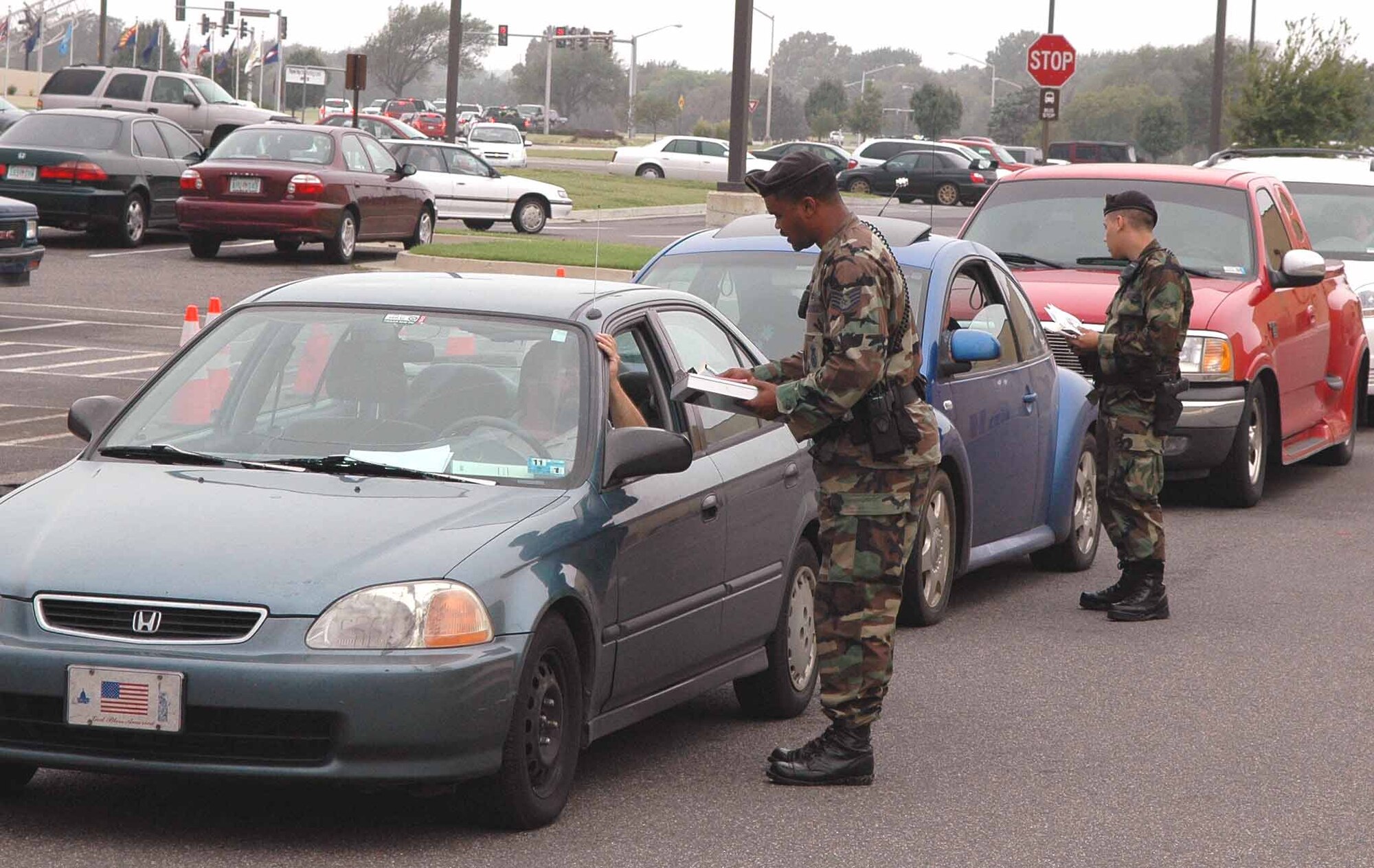 Two 72nd Security Forces Squadron members ticket a line of vehicles during a safety spot check Sept. 26 at the base exchange parking lot. (Air Force photo by Brandice J. Armstrong)