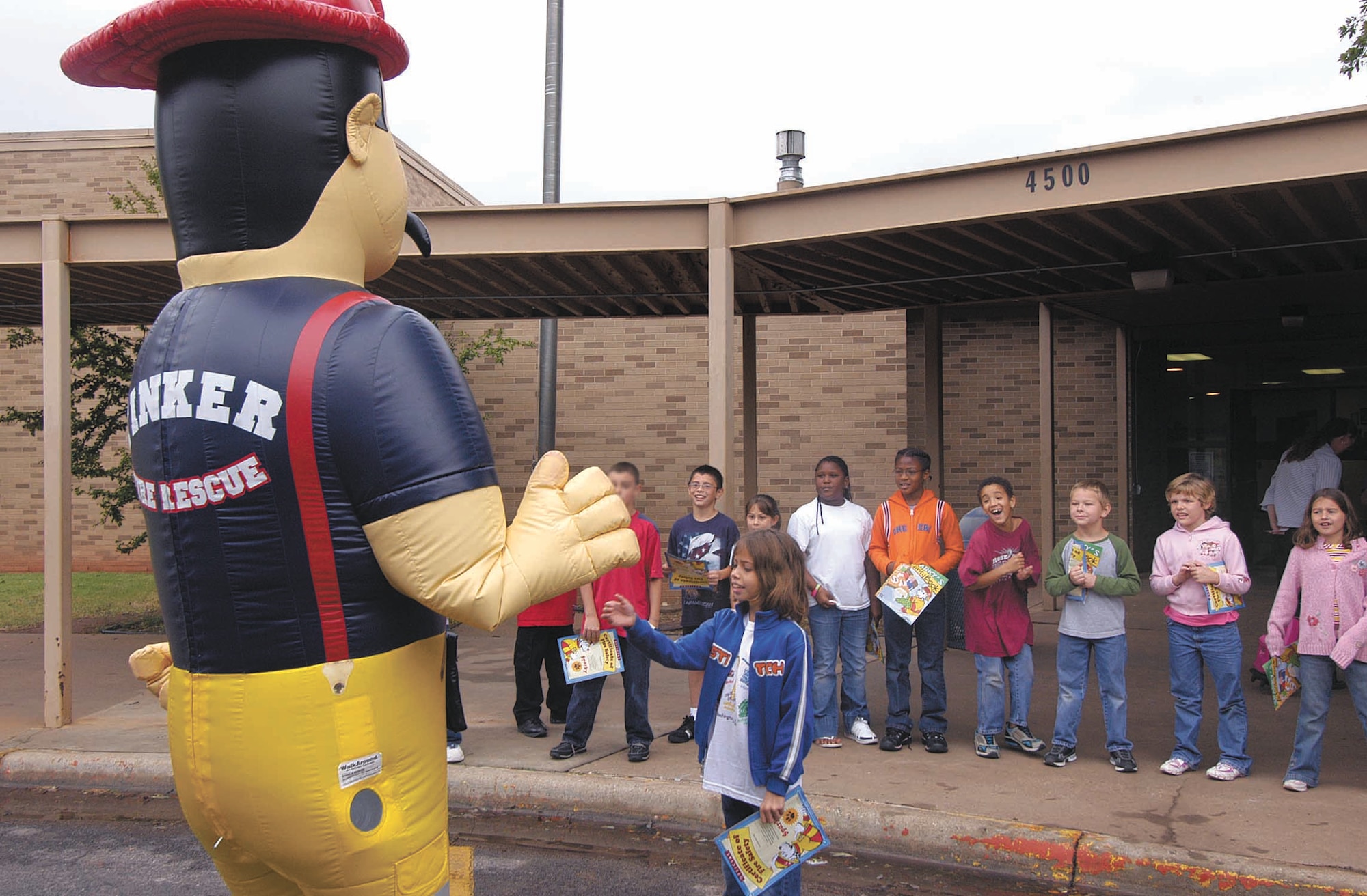 Big Kev waves to Tinker Elementary School students during a previous year’s Fire Prevention Week. This year’s activities include evacuation drills across base as well as the new Sparky’s House, a modified base housing residence used to teach kids how to escape house fires. (Air Force photo by Margo Wright)