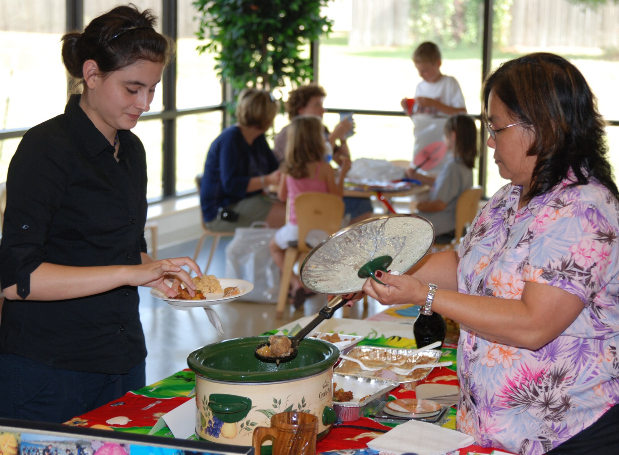 Michlene Tucker, 22nd Air Refueling Wing Equal Opportunity office, serves Hawaiian style sweet and sour ribs Sept. 29 at the International Fair held at the Youth Center. “I think it's important for children will come into contact with people from different cultures and customs,” said Ms. Tucker. “Whether you choose to travel the world or stay in one location, you will meet someone from a different culture.”  (photo by Airman 1st Class Jessica Lockoski)
 
