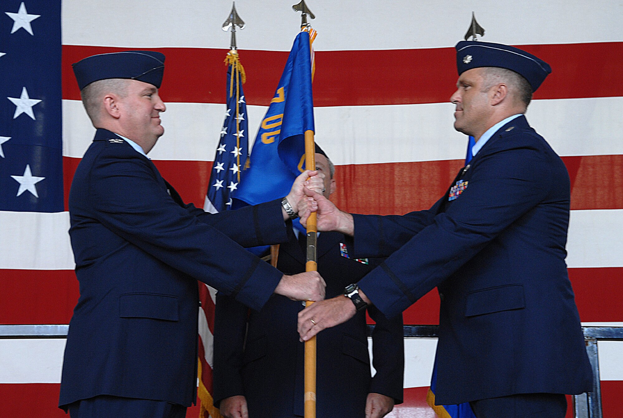DYESS AIR FORCE BASE, Texas -- Lt. Col. Gregory Payne (right) assumes command of the 7th Operations Support Squadron from Col. J.C. Valle, 7th Operations Group commander (left), Oct. 3 at the 3-Bay hangar. Outgoing was Lt. Col. Harry Foster. (U.S. Air Force photo by Airman 1st Class Jennifer Romig)