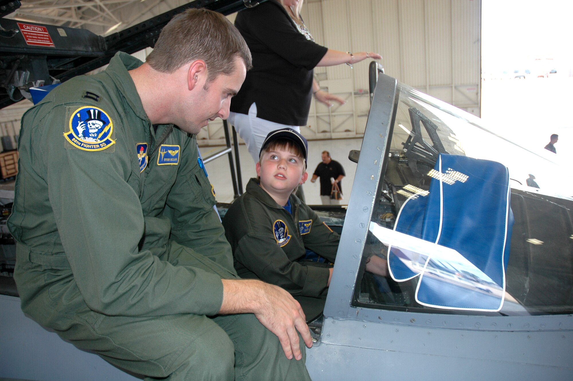 Capt. Ryan McLain explains to Dustin Murdock how some of the hundreds of switches operate in the cockpit of an F-15 Eagle during the Pilot for a Day program Oct. 2 at Tyndall Air Force Base, Fla.. Captain McLain is a pilot with the 95th Fighter Squadron.