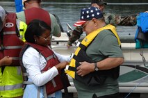 Geraldine Echols, a recreational therapist at the Murfreesboro VA hospital, helps secure a veteran’s life vest before a boat ride on Woods Reservoir. 