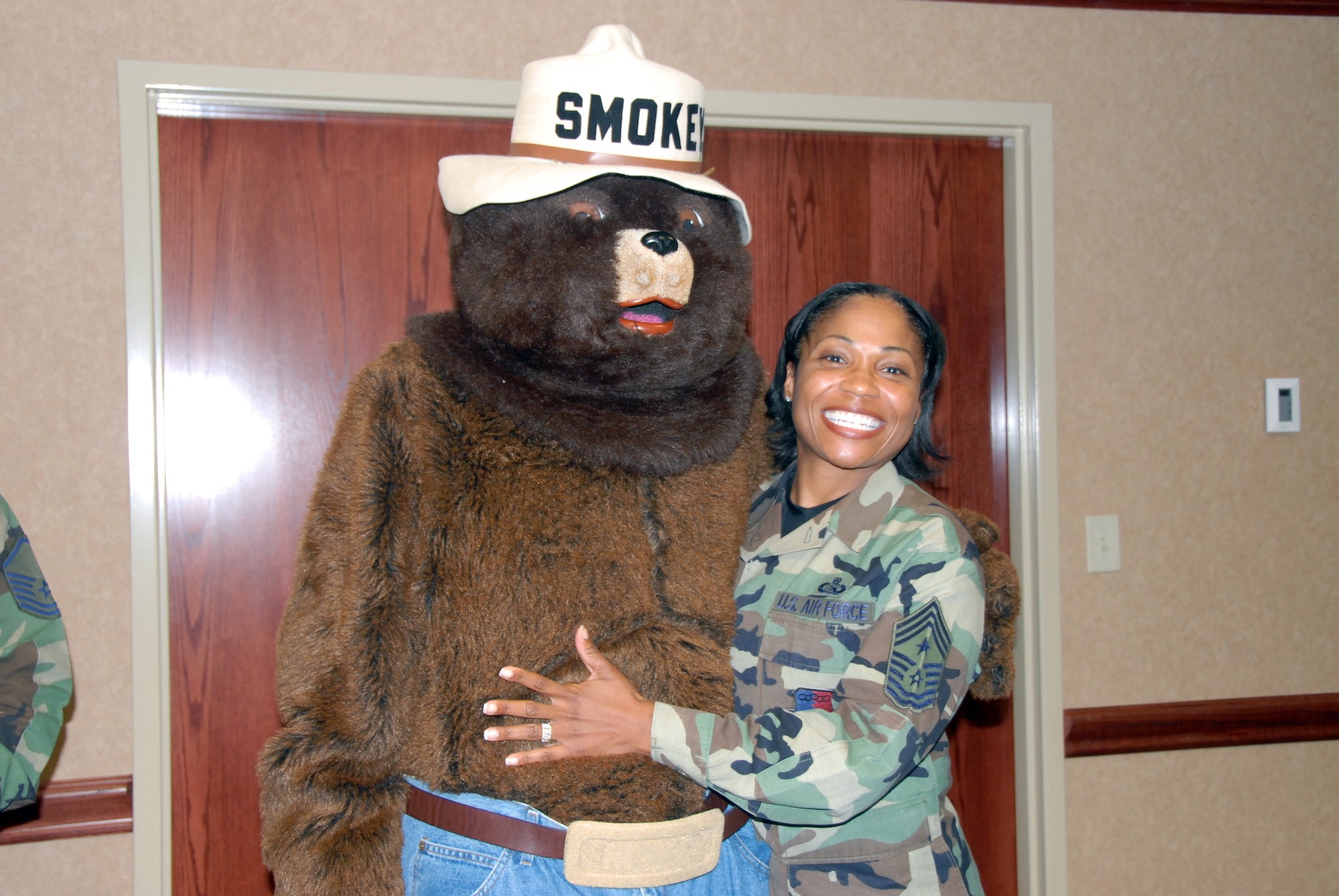 As part of the Fire Prevention Week campaign, Smokey the Bear visited the 78th Air Base Wing staff meeting, where he gave Chief Master Sgt. Carol Dockery, command chief, a big hug. (U. S. Air Force photo by Sue Sapp)