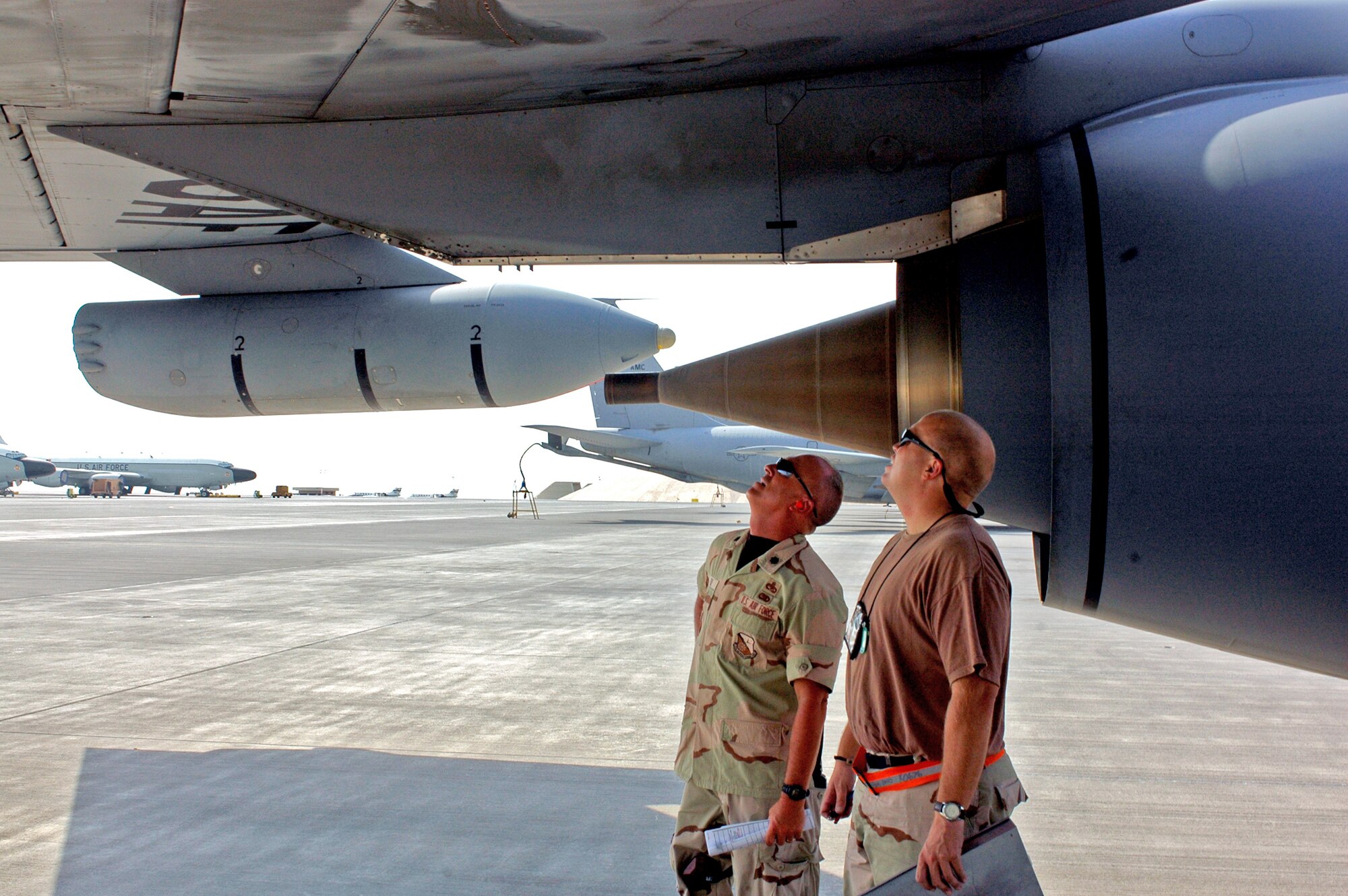 SOUTHWEST ASIA -- Left to right: Lt. Col. Scott Fike, 379th Expeditonary Maintenance Group vice commander, and Tech. Sgt. Kevin Kuehn, 340th Aircraft Maintenance Unit specialist expeditor, analyze and discuss a hydraulic fluid leak on a KC-135. The aircraft was venting to relieve pressure caused by the excessive heat. The KC-135 is allowed to "leak" to a certain limit according to maintenance technical data. (U.S. Air Force photo/Staff Sgt. Jason Barebo)