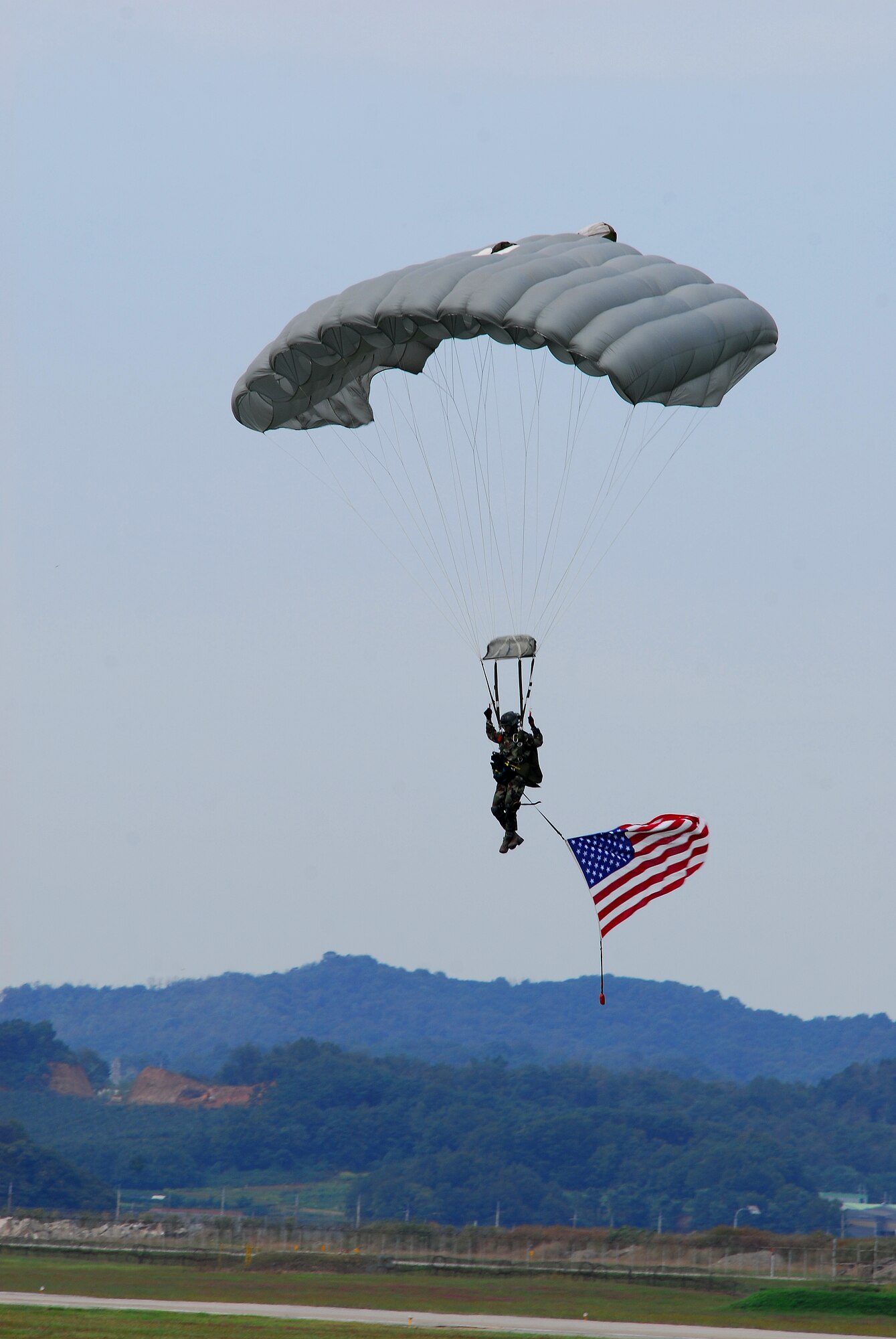 OSAN AIR BASE, Republic of Korea --  A member of the pararescue demonstration team parachutes onto the flightline during the opening ceremony of Air Power Day 2007 on Oct. 6 here. (U.S. Air Force photo by Airman 1st Class Chad Strohmeyer)